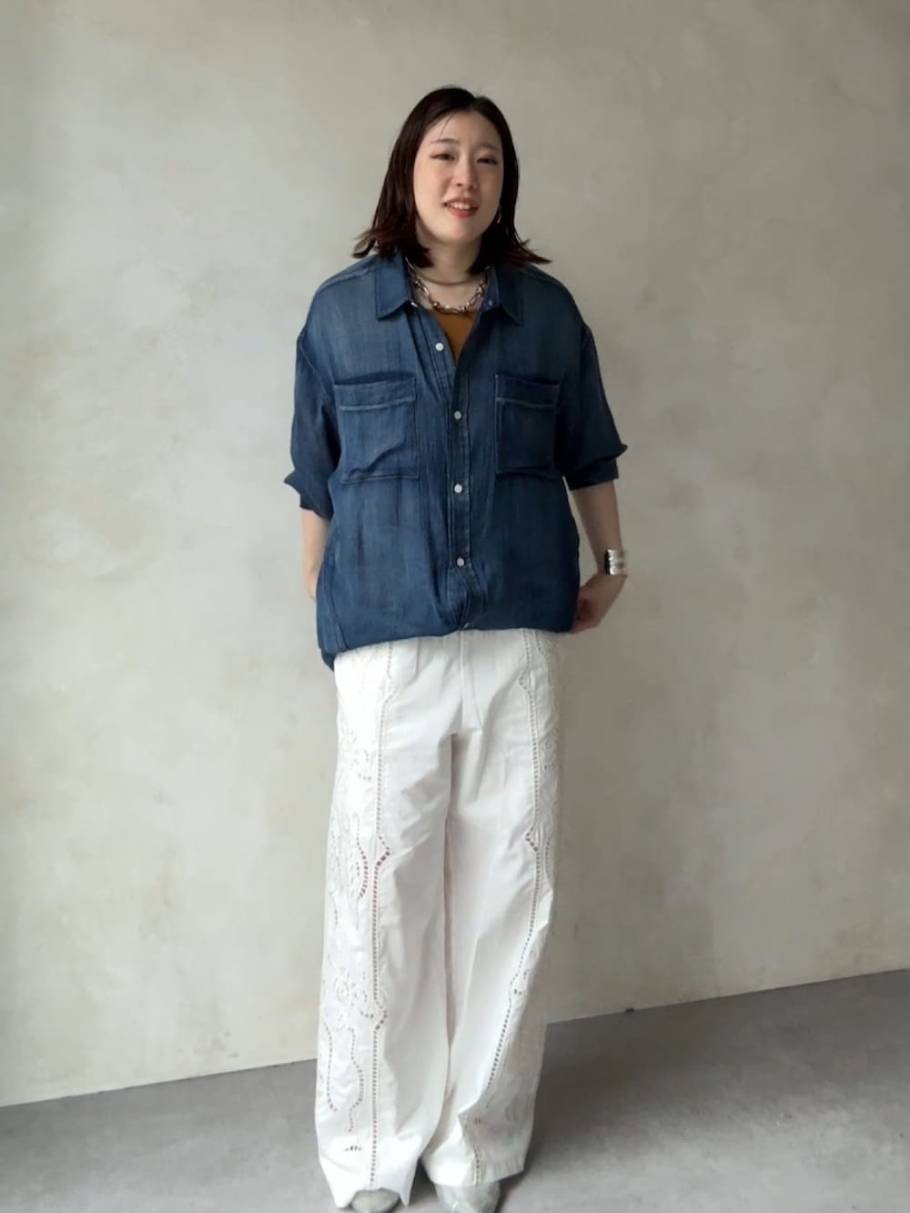 イエロー系のタンクトップ、ブルー系のシャツ/ブラウス、ホワイト系のその他パンツを着用したレディースの春コーディネートの2枚目の写真