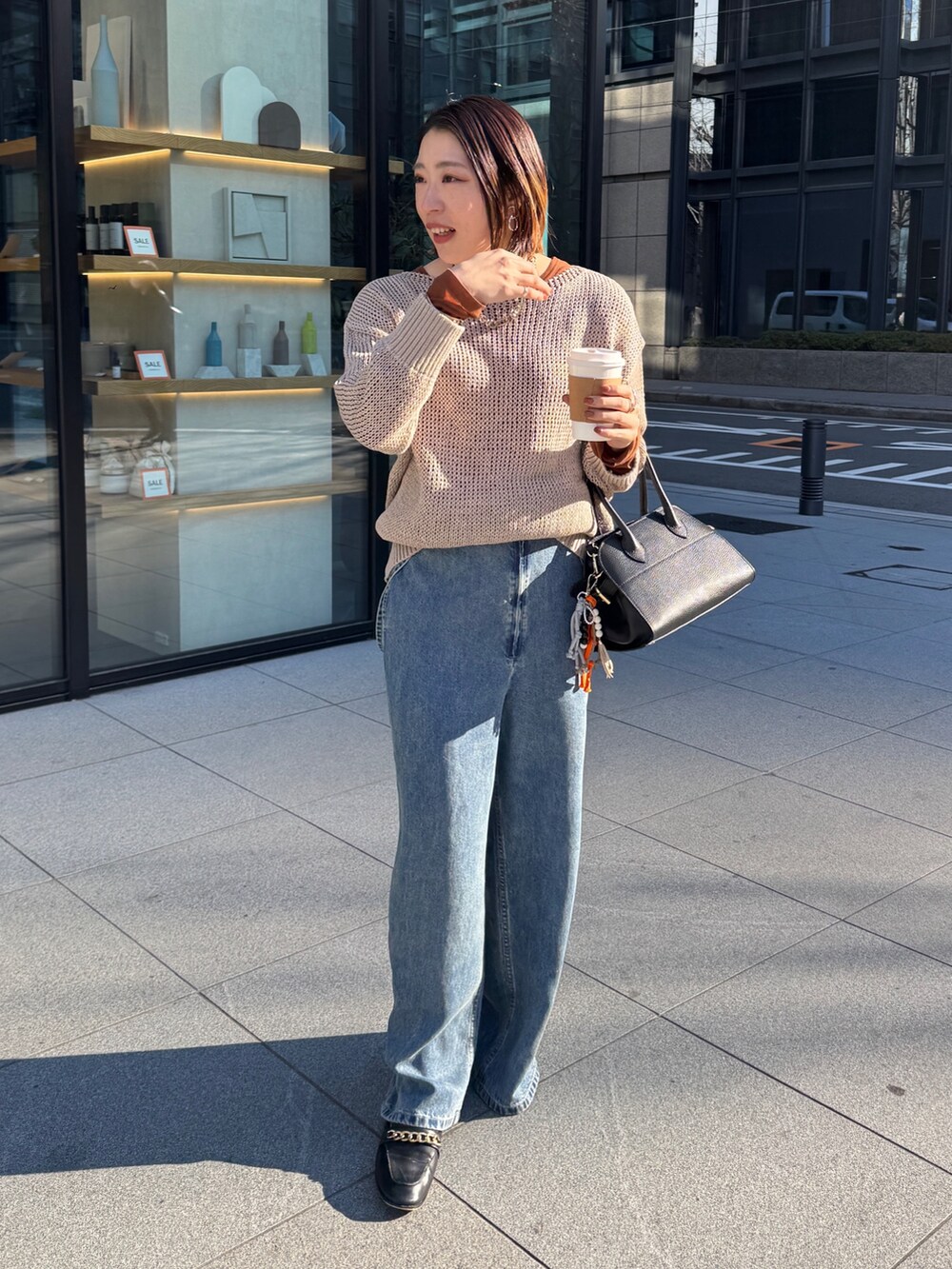 ベージュ系のニット/セーター、ブルー系のデニムパンツ、ブラウン系のTシャツ/カットソーを着用したレディースの冬コーディネートの8枚目の写真