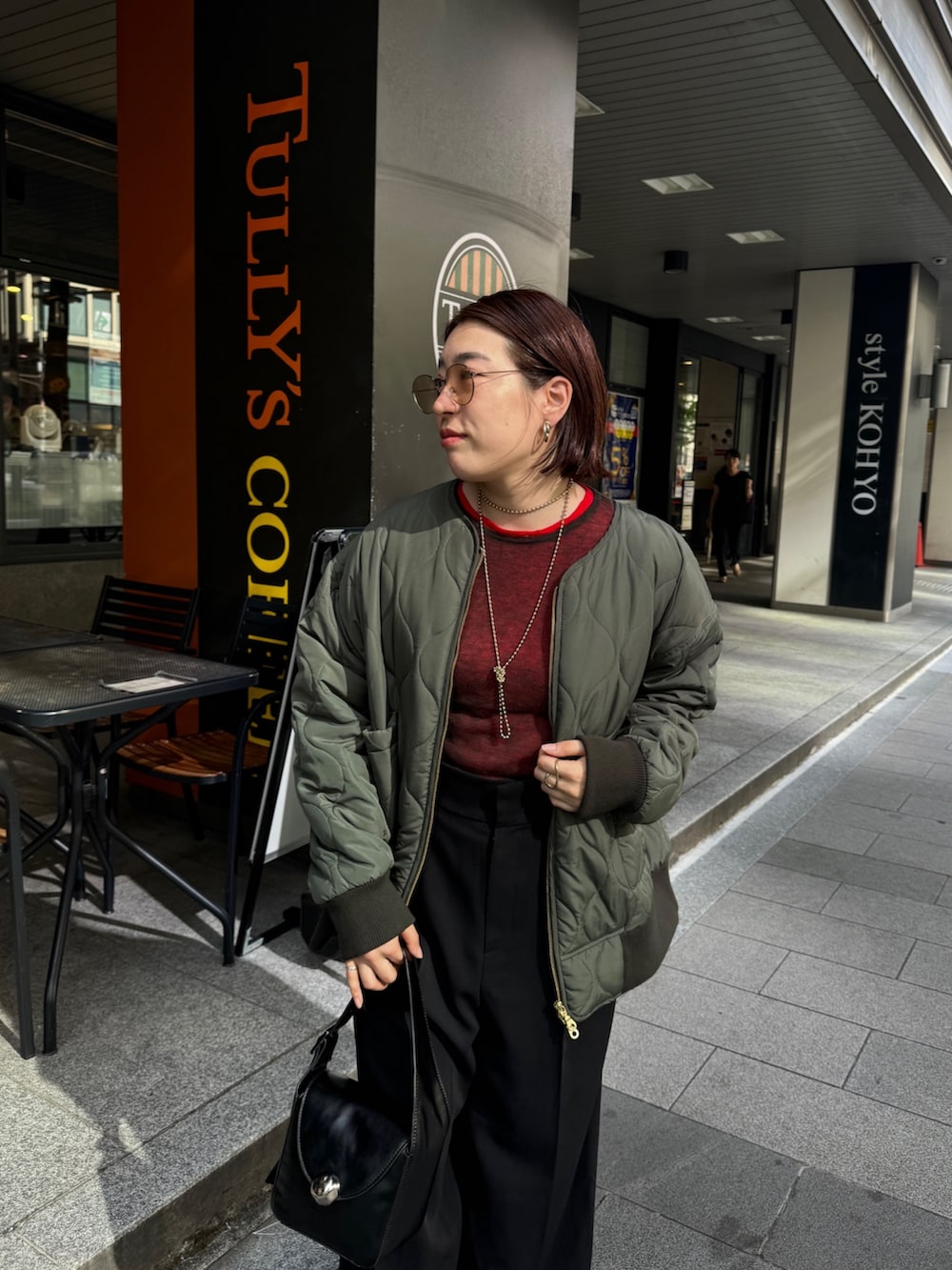 ブラック系のその他パンツ、グリーン系のその他アウター、レッド系のニット/セーターを着用したレディースの秋コーディネートの6枚目の写真