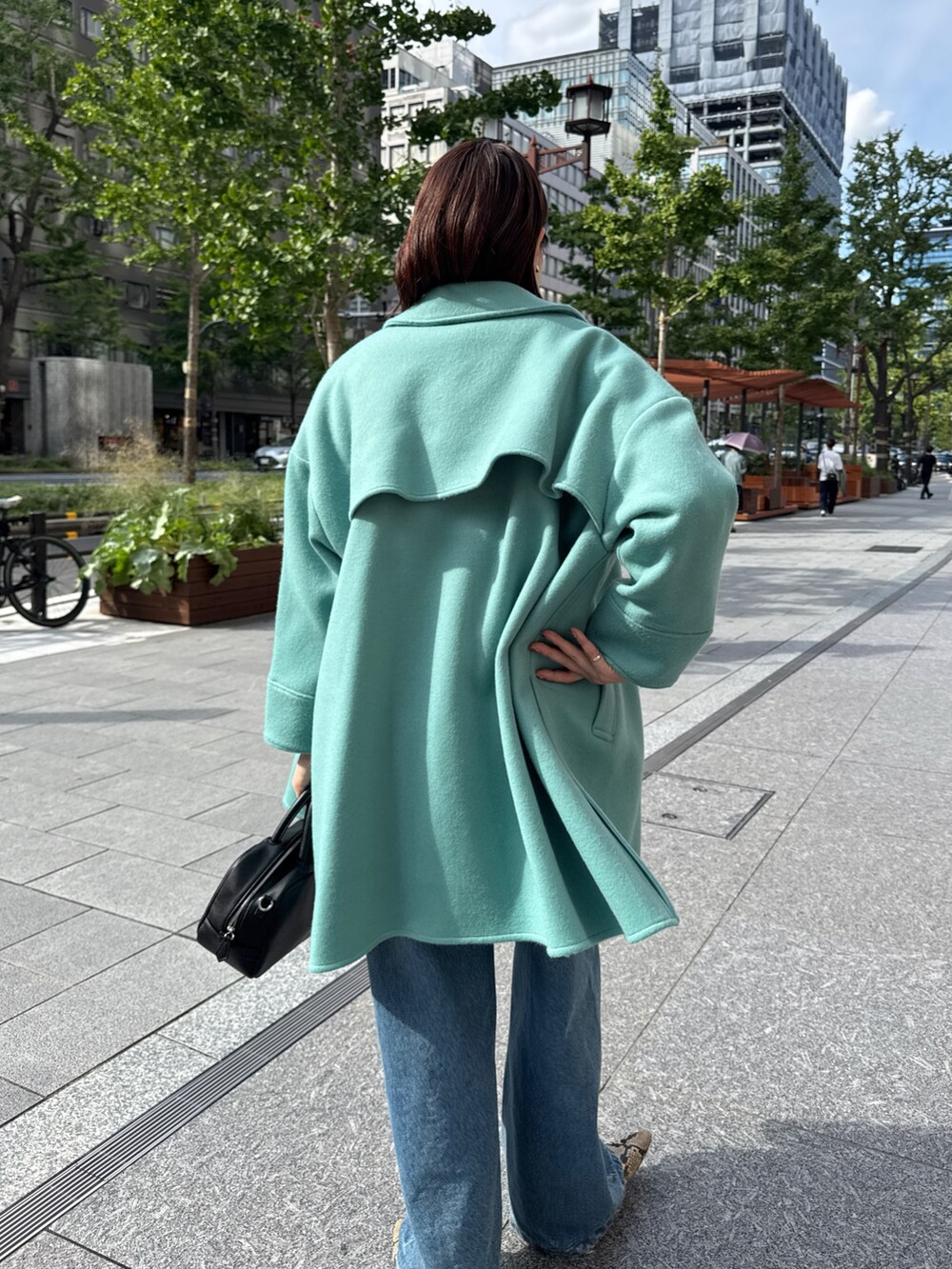 ベージュ系のニット/セーター、グリーン系のその他アウター、ブルー系のデニムパンツを着用したレディースの秋コーディネートの8枚目の写真