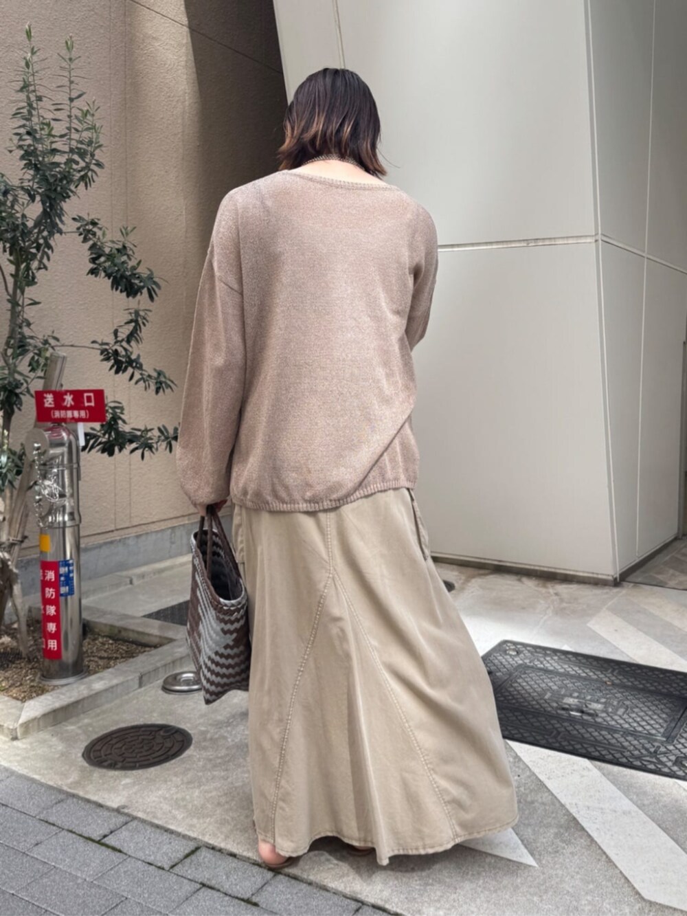 ベージュ系のスカート、ゴールド系のネックレスを着用したレディースの春コーディネートの7枚目の写真