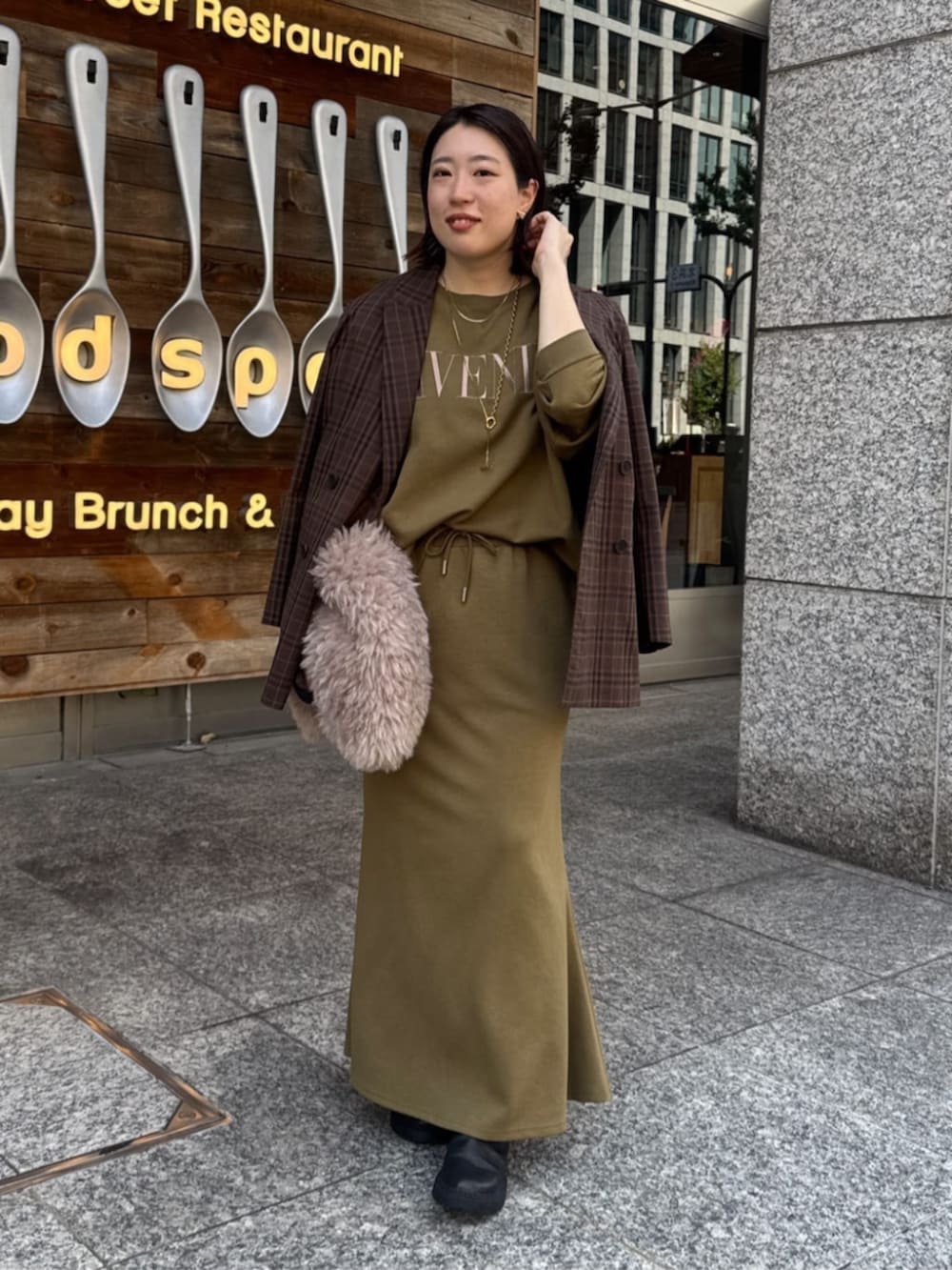 グリーン系のTシャツ/カットソー、グリーン系のスカート、ブラウン系のテーラードジャケットを着用したレディースの夏コーディネートの3枚目の写真