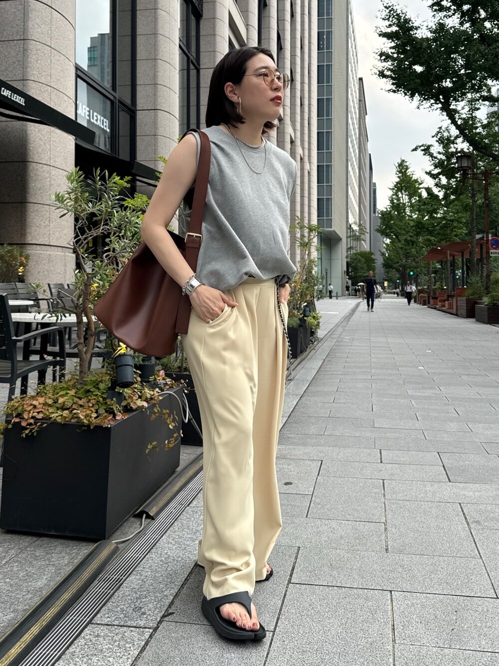 イエロー系のスラックス、グレー系のスウェット、シルバー系のベルトを着用したレディースの夏コーディネートの5枚目の写真