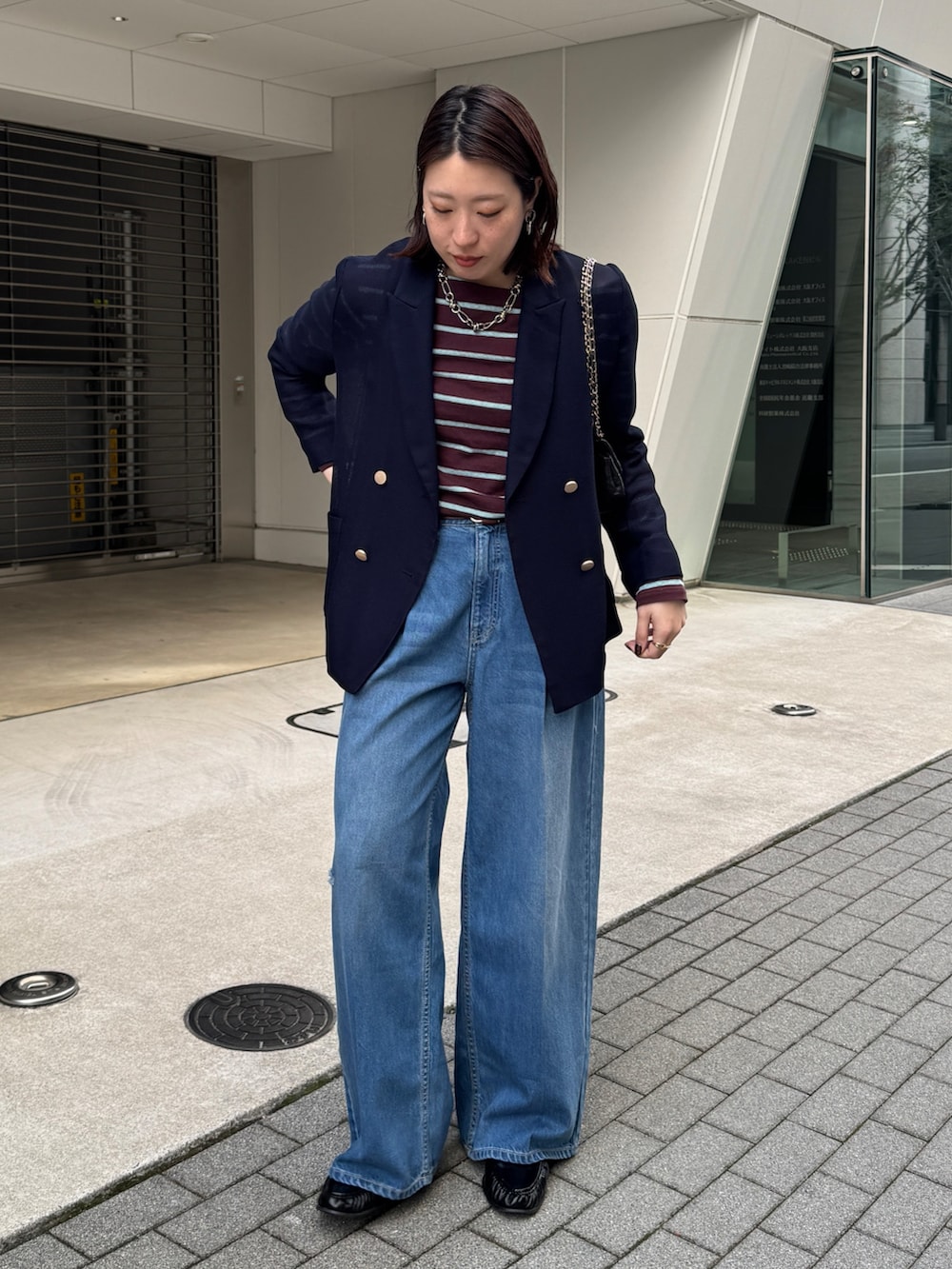 ブルー系のデニムパンツ、ブルー系のテーラードジャケット、ブラウン系のTシャツ/カットソーを着用したレディースの春コーディネートの2枚目の写真