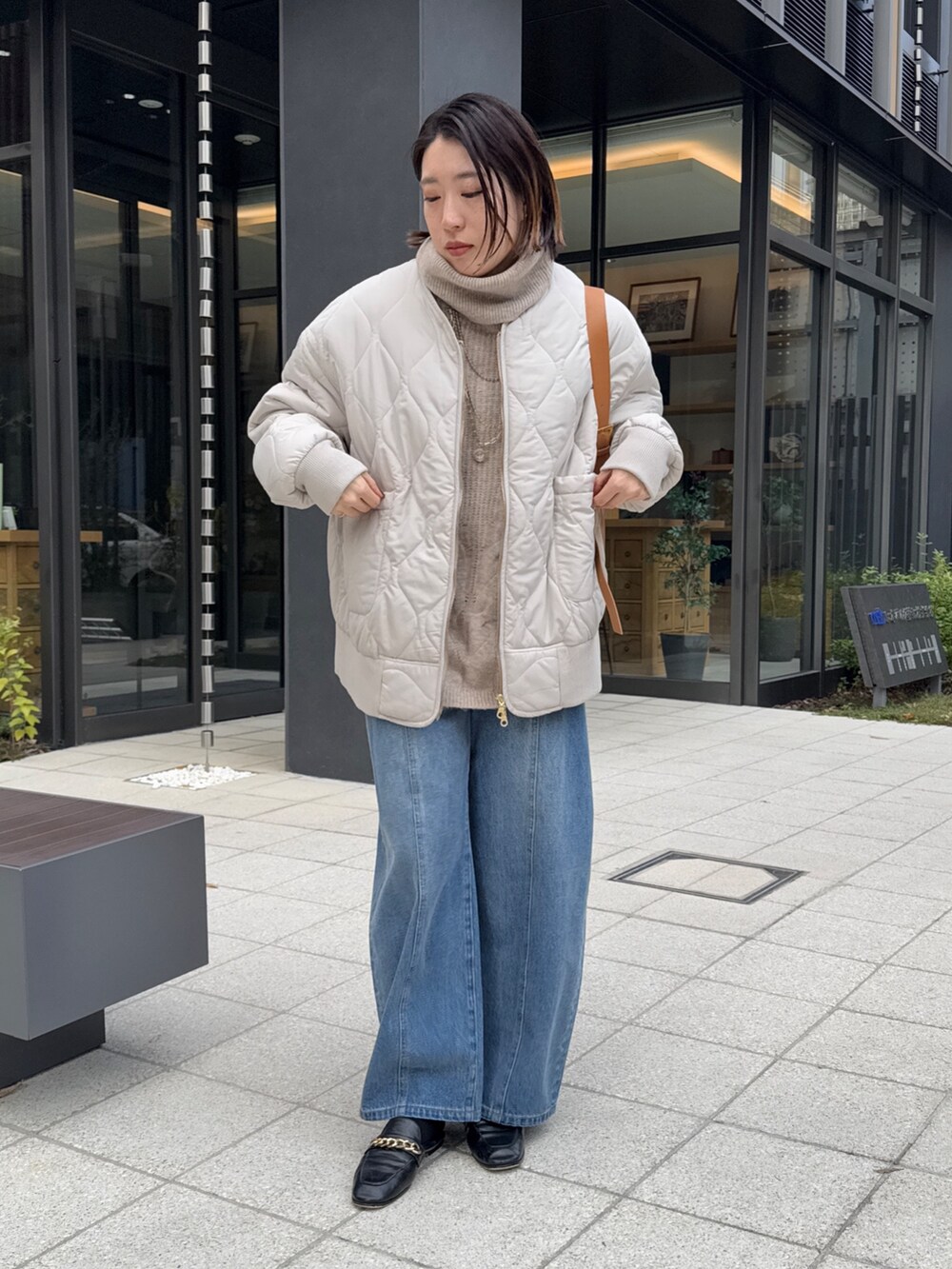 ホワイト系のその他アウター、ベージュ系のニット/セーター、ブルー系のデニムパンツを着用したレディースの冬コーディネートの3枚目の写真