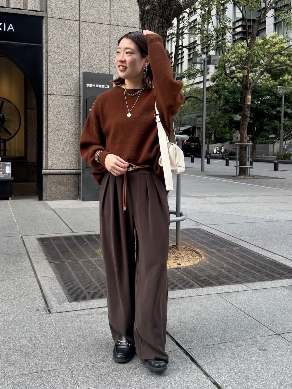 ブラウン系のニット/セーター、ブラウン系のスラックス、ブラウン系のベルトを着用したレディースの秋コーディネートの6枚目の写真