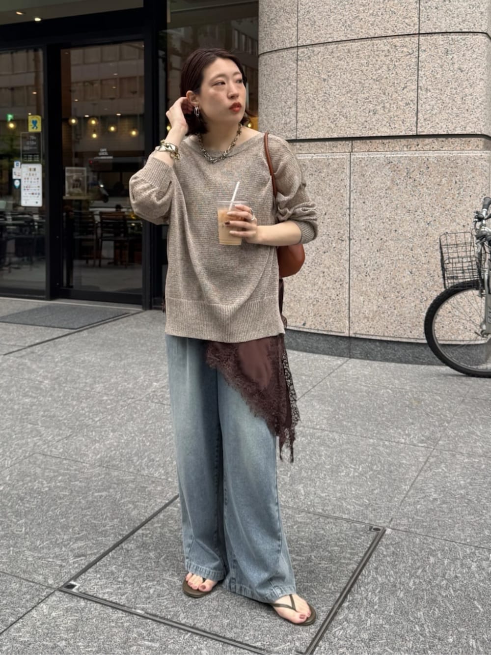 ブルー系のデニムパンツ、ブラウン系のキャミソール、ベージュ系のカーディガン/ボレロを着用したレディースの春コーディネートの3枚目の写真