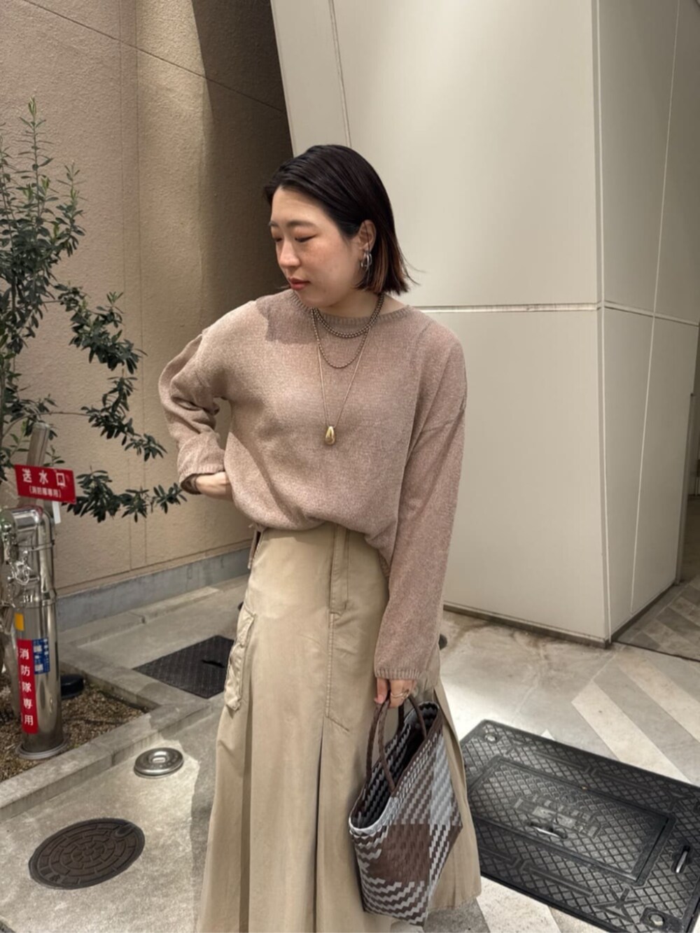 ベージュ系のスカート、ゴールド系のネックレスを着用したレディースの春コーディネートの9枚目の写真