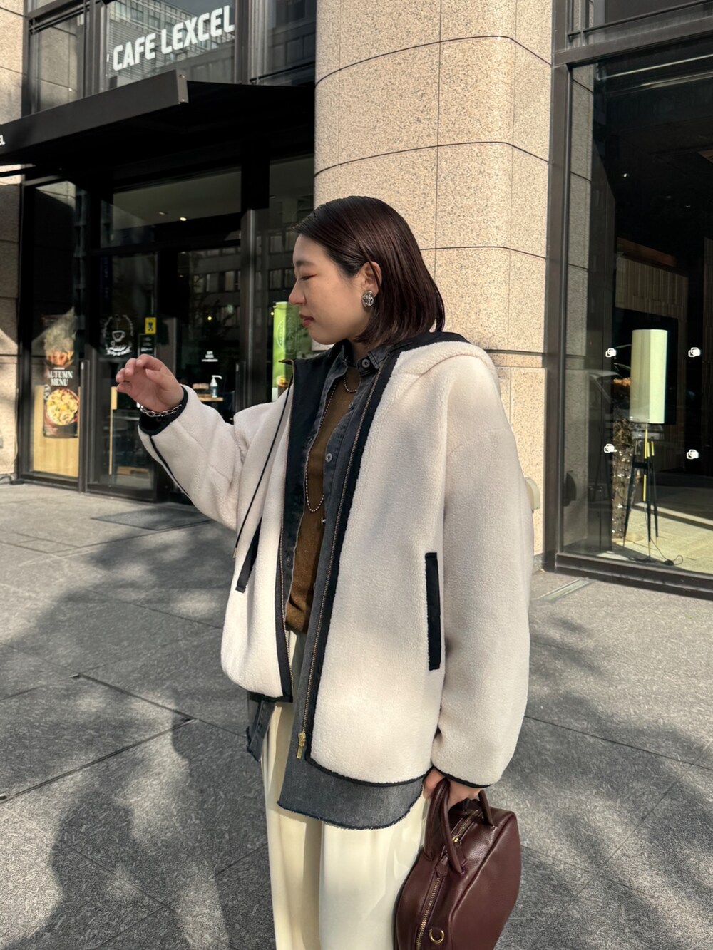 ホワイト系のその他アウター、ブルー系のシャツ/ブラウス、ブラウン系のTシャツ/カットソーを着用したレディースの秋コーディネートの7枚目の写真