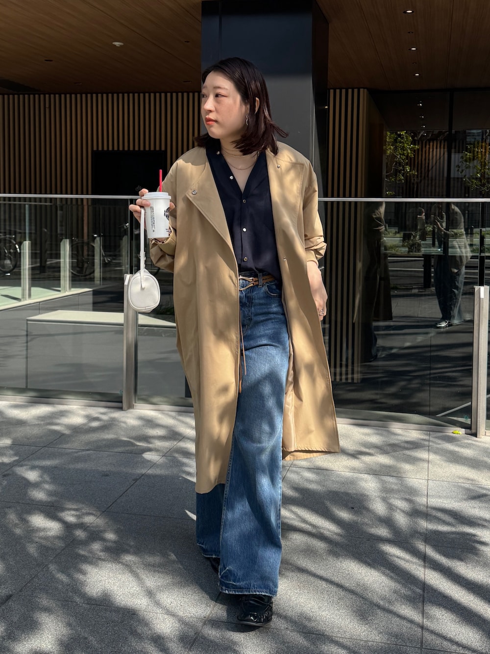 ブルー系のデニムパンツ、イエロー系のその他アウター、ブルー系のシャツ/ブラウスを着用したレディースの春コーディネートの5枚目の写真