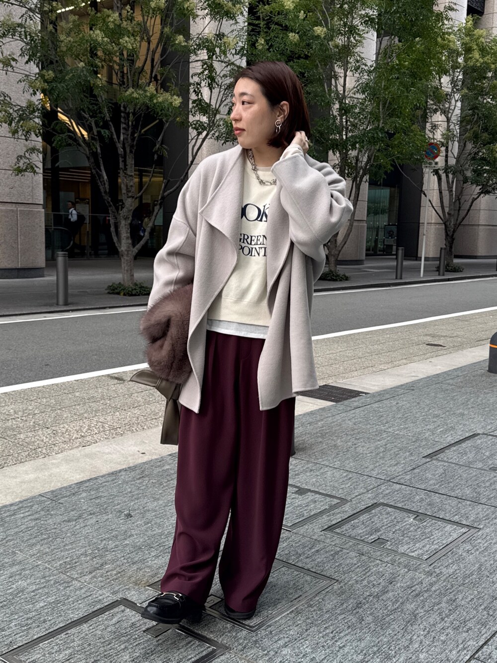 レッド系のスラックス、ベージュ系のその他アウター、ホワイト系のニット/セーターを着用したレディースの秋コーディネートの5枚目の写真