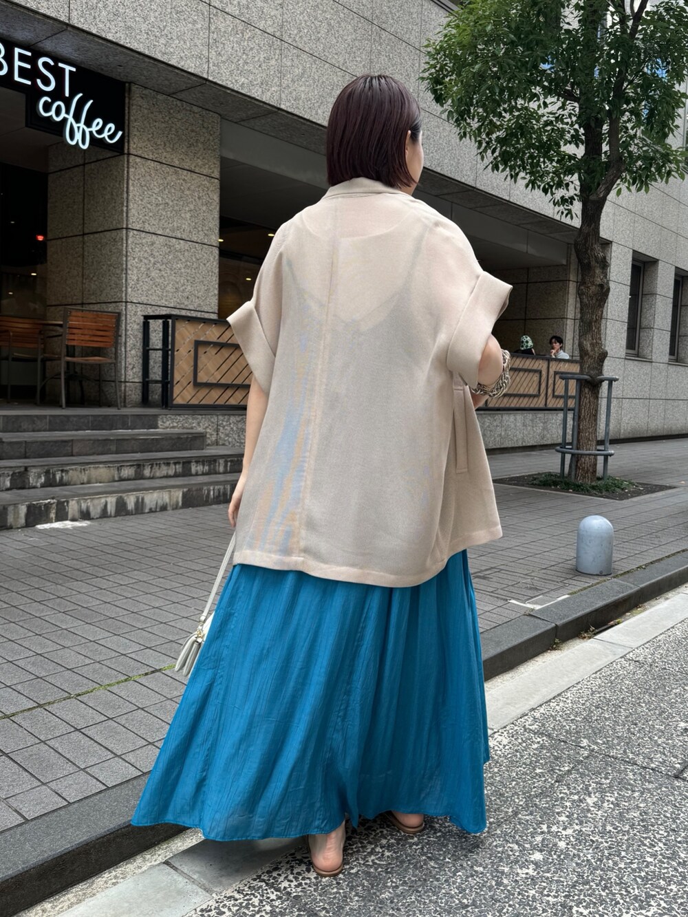 ベージュ系のテーラードジャケット、ホワイト系のタンクトップ、ブルー系のワンピースを着用したレディースの夏コーディネートの4枚目の写真