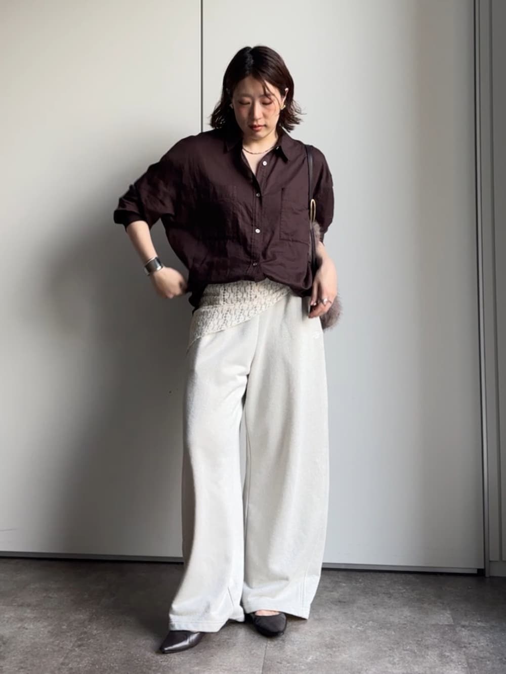 ブラウン系のシャツ/ブラウス、ホワイト系のスウェットパンツ、ブラウン系のトートバッグを着用したレディースの秋コーディネートの2枚目の写真