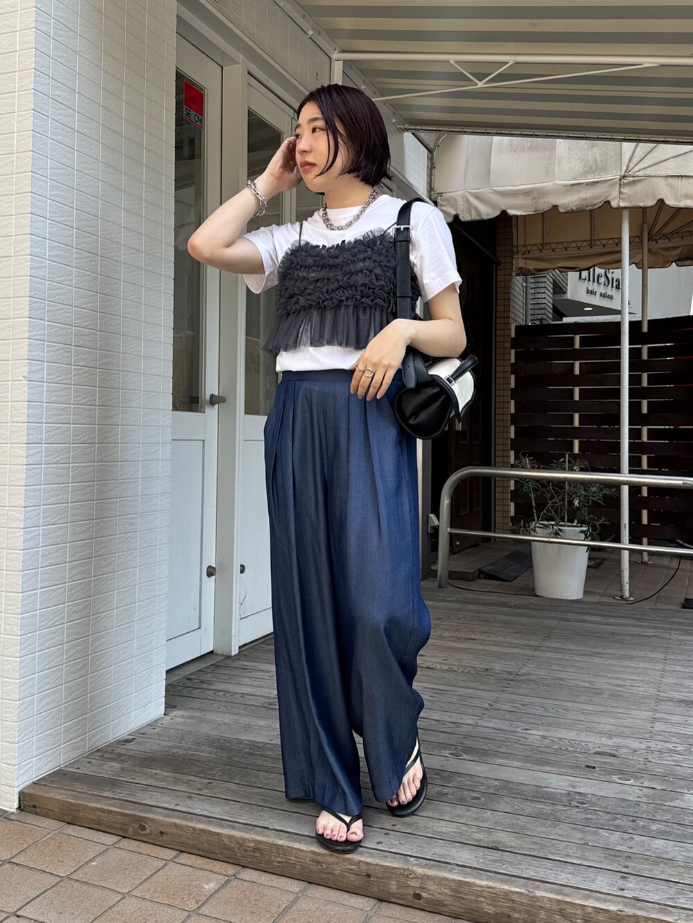 ブルー系のデニムパンツ、ホワイト系のTシャツ/カットソー、グレー系のキャミソールを着用したレディースの夏コーディネートの7枚目の写真