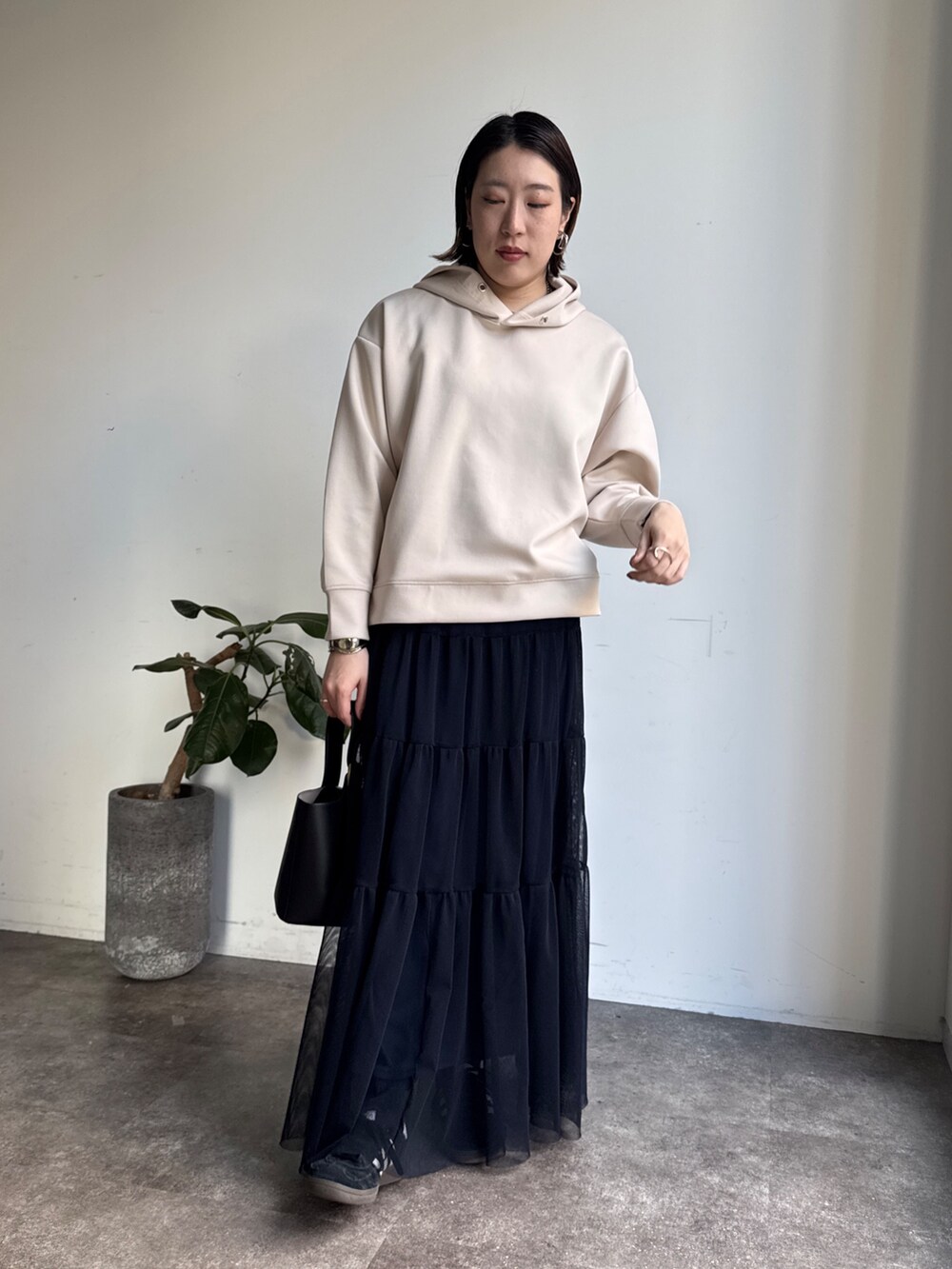 ホワイト系のセットアップ、ブルー系のスカートを着用したレディースの冬コーディネートの9枚目の写真