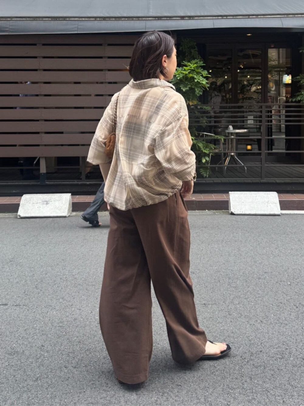 イエロー系のショルダーバッグ、ベージュ系のシャツ/ブラウス、ベージュ系のその他パンツを着用したレディースの夏コーディネートの3枚目の写真