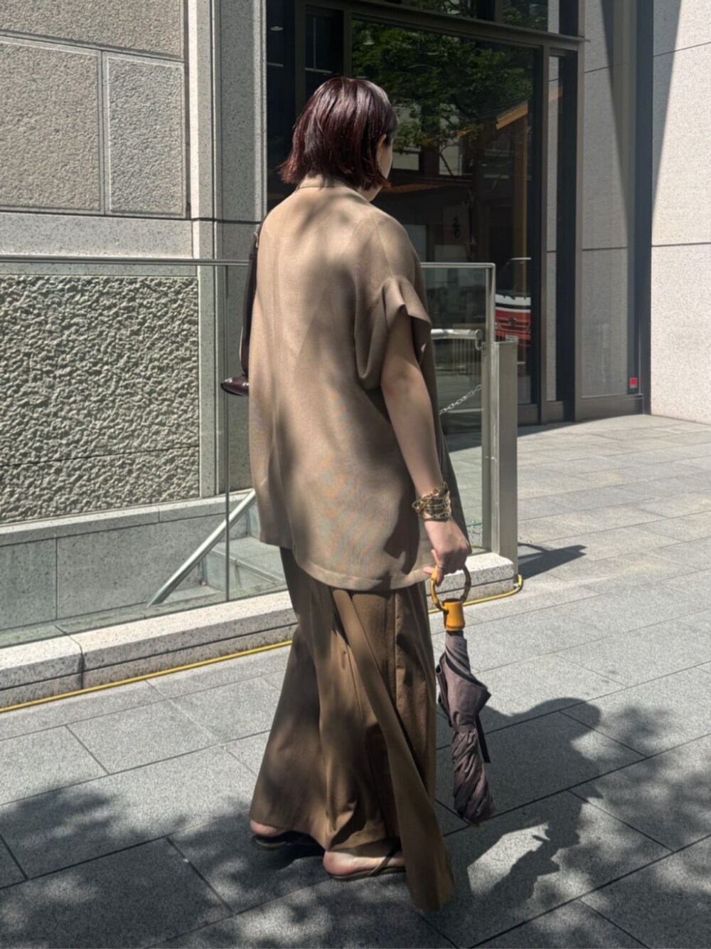 ホワイト系のタンクトップ、ブラウン系のテーラードジャケット、ベージュ系のワンピースを着用したレディースの夏コーディネートの5枚目の写真