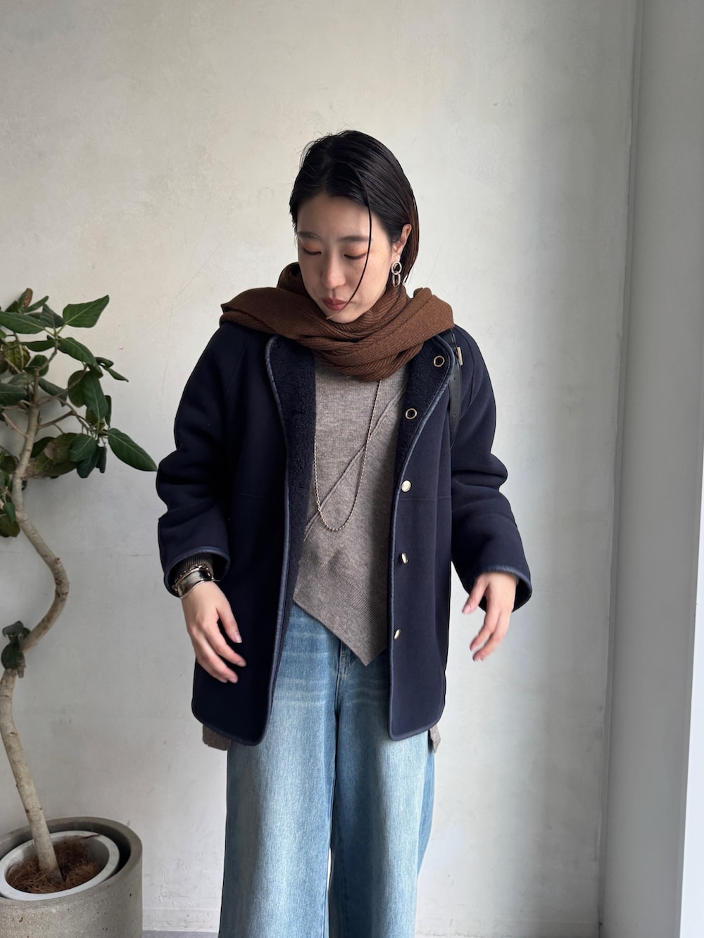 ブルー系のその他アウター、ブルー系のデニムパンツ、グリーン系のニット/セーターを着用したレディースの秋コーディネートの3枚目の写真