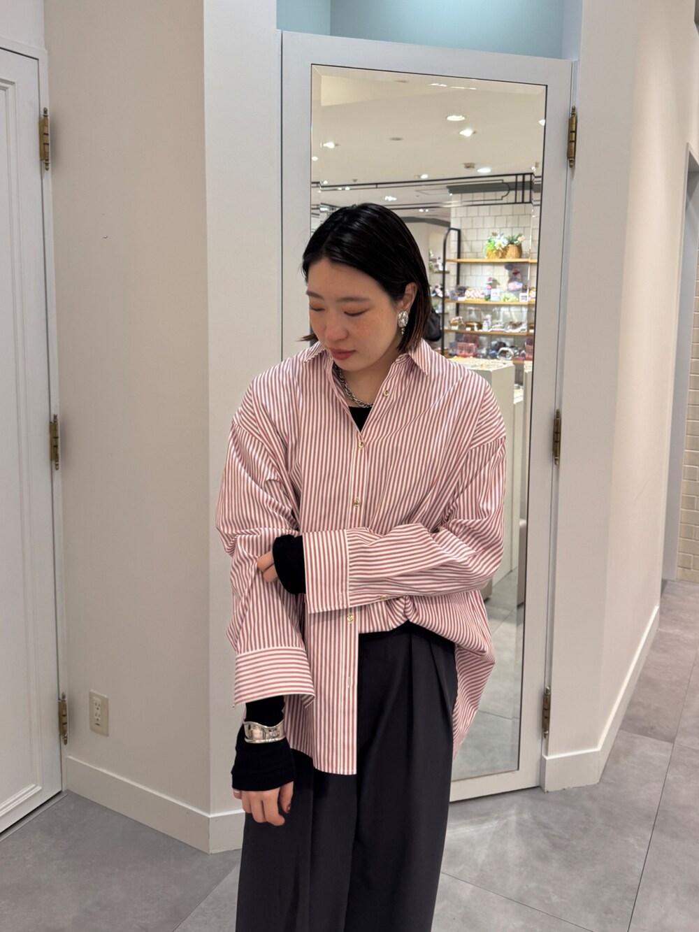 ブラウン系のスラックス、レッド系のシャツ/ブラウス、ブルー系のTシャツ/カットソーを着用したレディースの春コーディネートの6枚目の写真