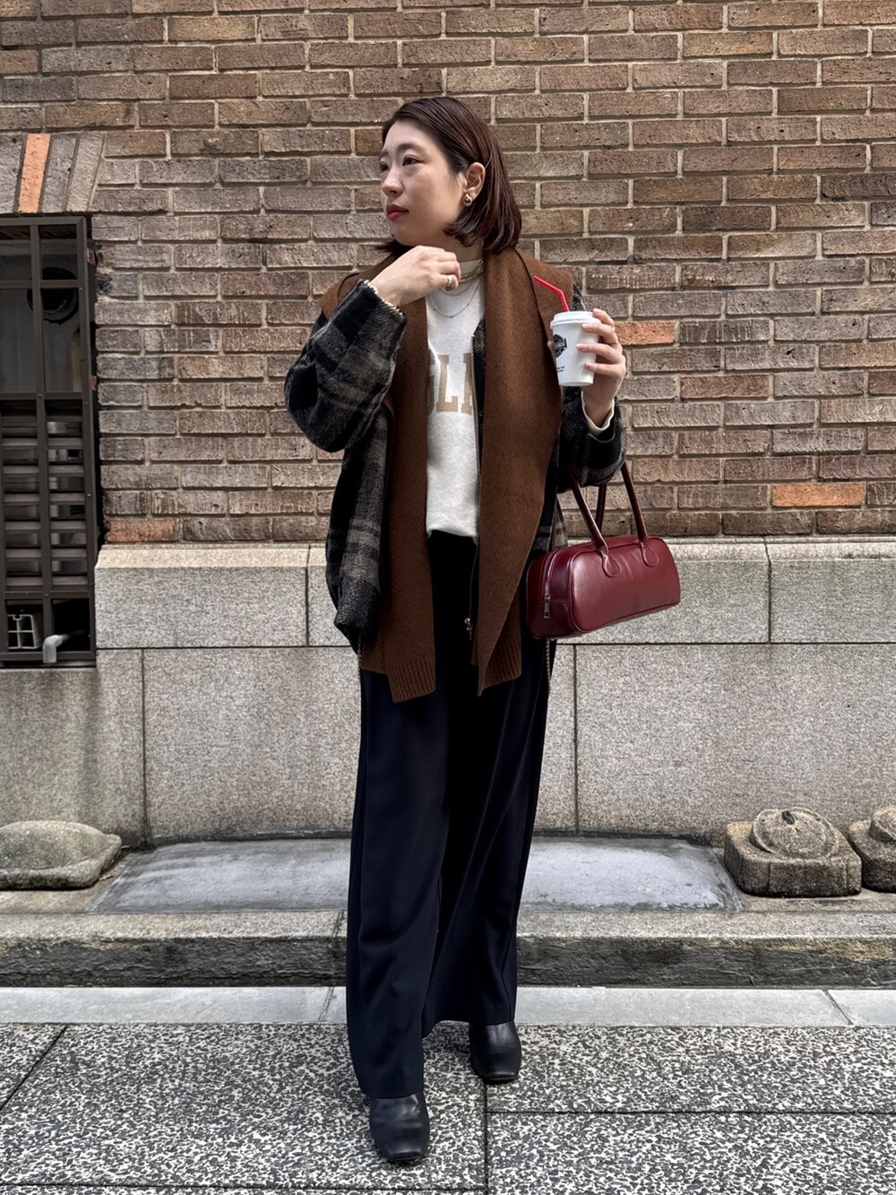 ブルー系のスラックス、ホワイト系のニット/セーター、レッド系のショルダーバッグを着用したレディースの秋コーディネートの6枚目の写真