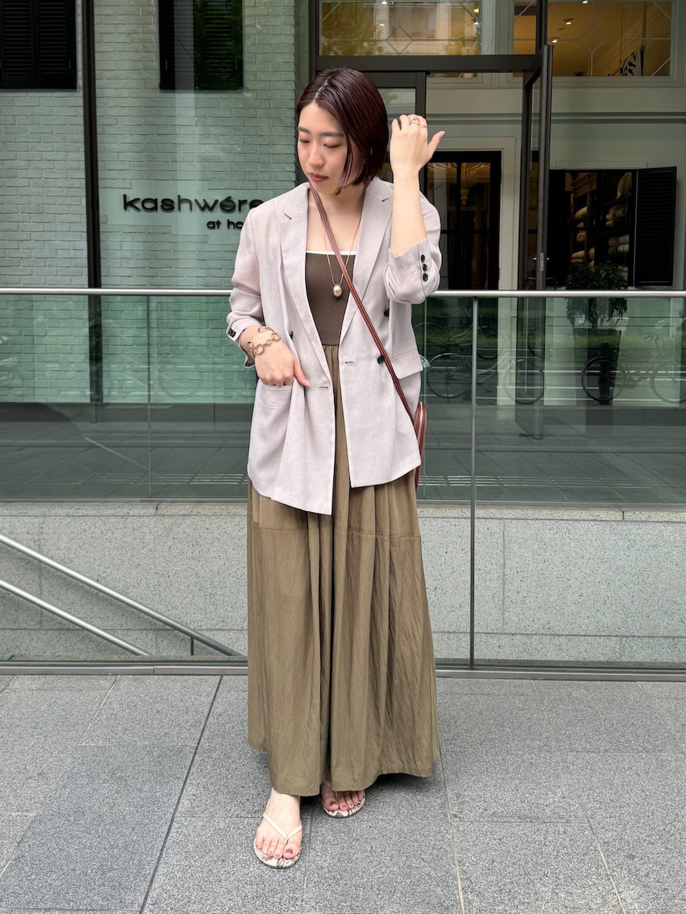 グリーン系のワンピース、ベージュ系のテーラードジャケット、ゴールド系のネックレスを着用したレディースの夏コーディネートの5枚目の写真