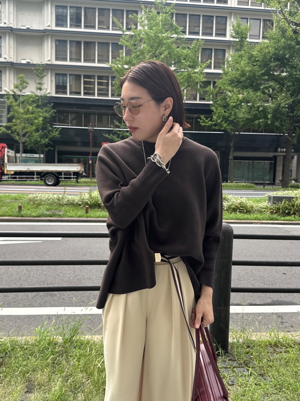 イエロー系のスラックス、ブラウン系のニット/セーター、ゴールド系のネックレスを着用したレディースの秋コーディネートの8枚目の写真