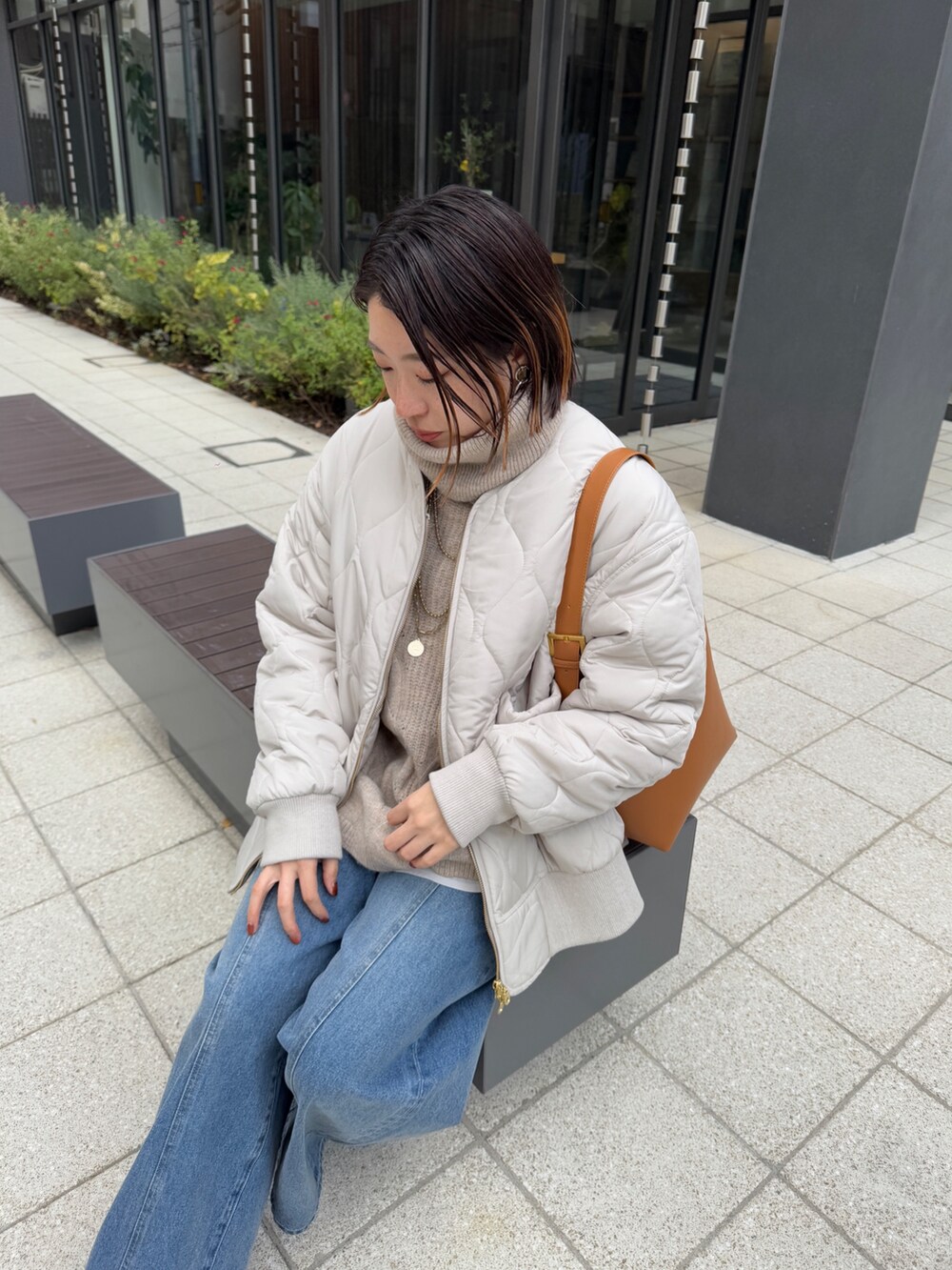 ホワイト系のその他アウター、ベージュ系のニット/セーター、ブルー系のデニムパンツを着用したレディースの冬コーディネートの4枚目の写真