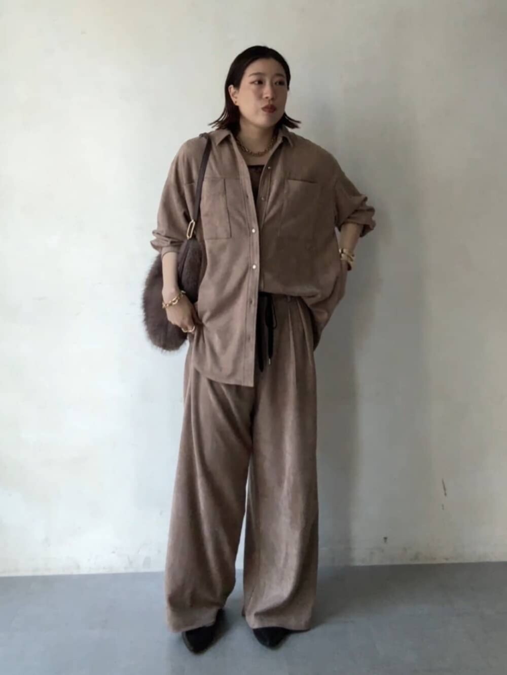 ブラウン系のパンプス、ブラウン系のシャツ/ブラウス、ブラウン系のショルダーバッグを着用したレディースの秋コーディネートの4枚目の写真