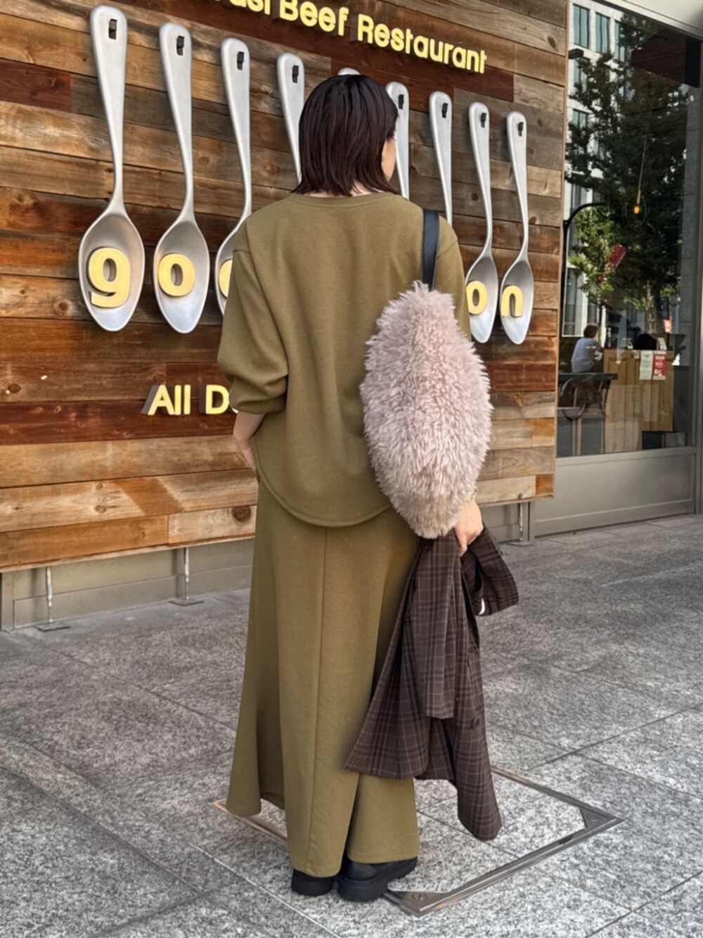 グリーン系のTシャツ/カットソー、グリーン系のスカート、ブラウン系のテーラードジャケットを着用したレディースの夏コーディネートの2枚目の写真