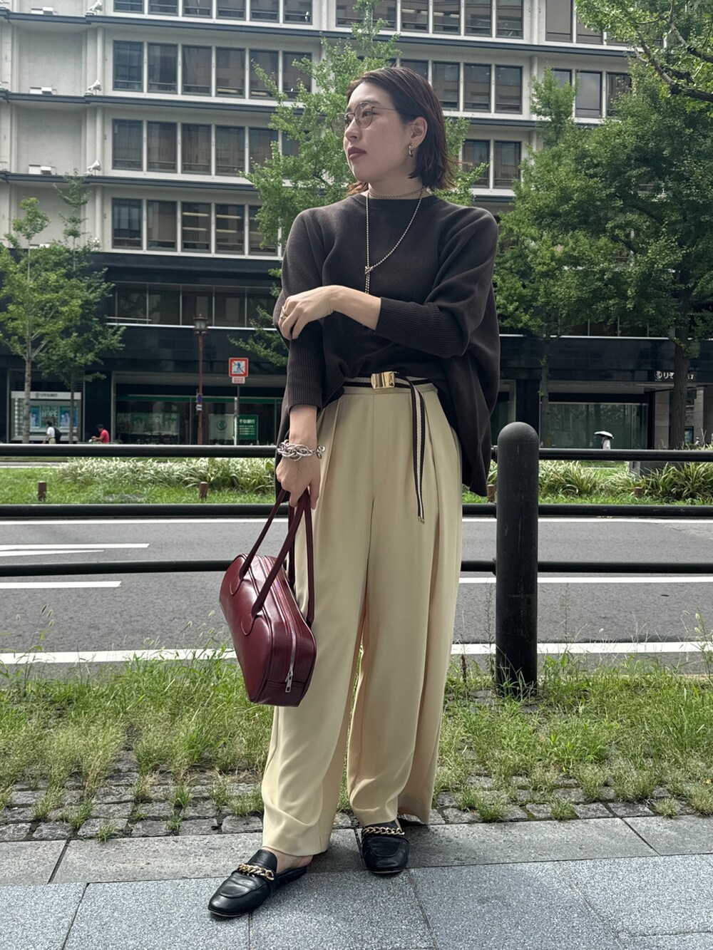 イエロー系のスラックス、ブラウン系のニット/セーター、ゴールド系のネックレスを着用したレディースの秋コーディネートの7枚目の写真