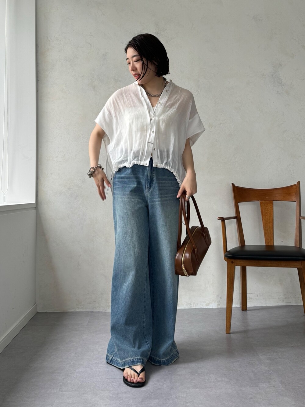 ブルー系のデニムパンツ、ホワイト系のシャツ/ブラウスを着用したレディースの夏コーディネートの5枚目の写真