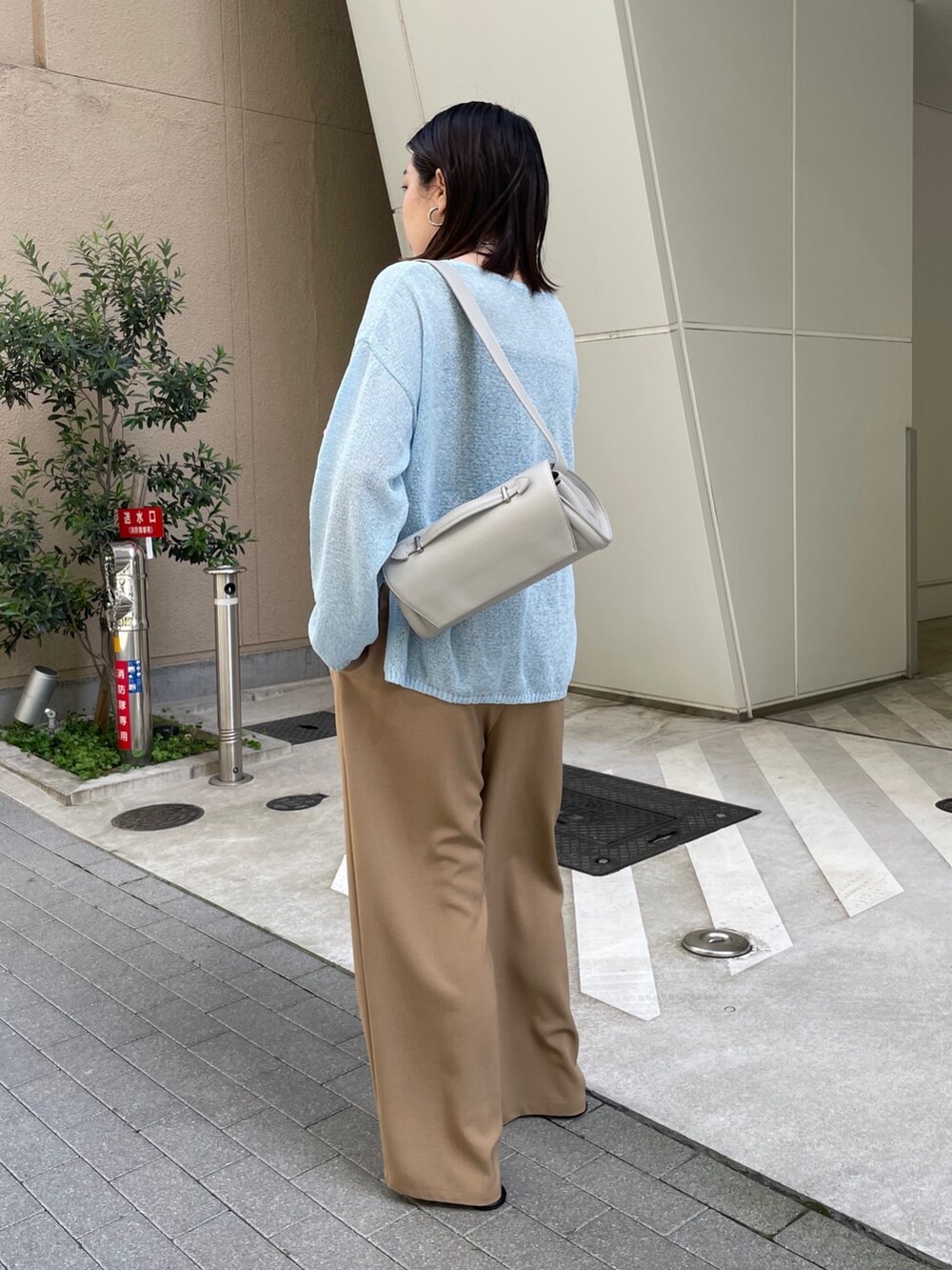 グレー系のスラックス、ブルー系のニット/セーター、ブルー系のベルトを着用したレディースの春コーディネートの7枚目の写真
