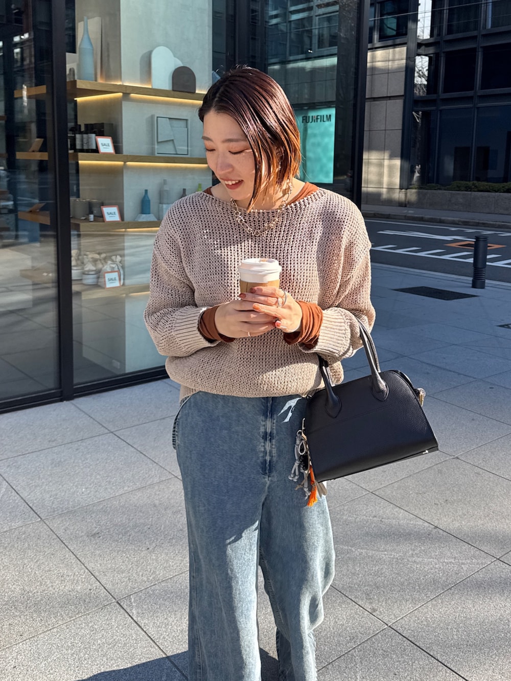 ベージュ系のニット/セーター、ブルー系のデニムパンツ、ブラウン系のTシャツ/カットソーを着用したレディースの冬コーディネートの9枚目の写真
