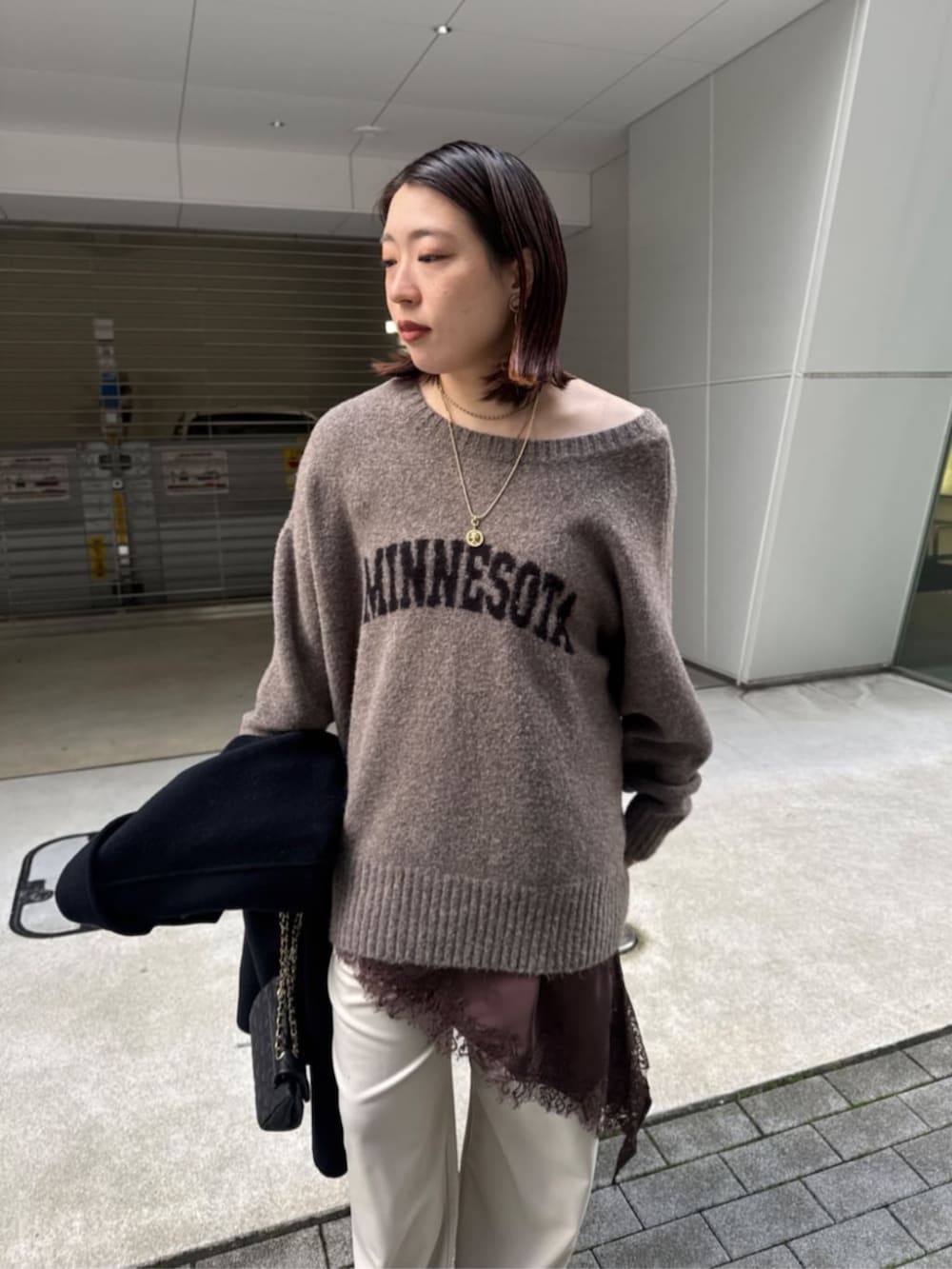 ブラック系のショルダーバッグ、ベージュ系のニット/セーター、ブラウン系のキャミソールを着用したレディースの秋コーディネートの6枚目の写真