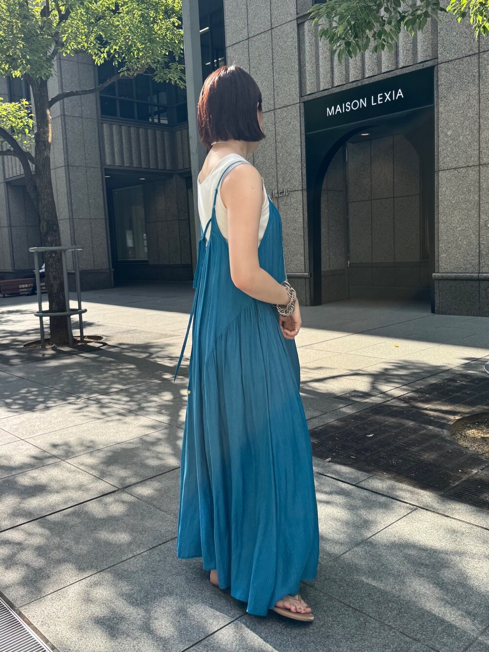 ベージュ系のテーラードジャケット、ホワイト系のタンクトップ、ブルー系のワンピースを着用したレディースの夏コーディネートの8枚目の写真