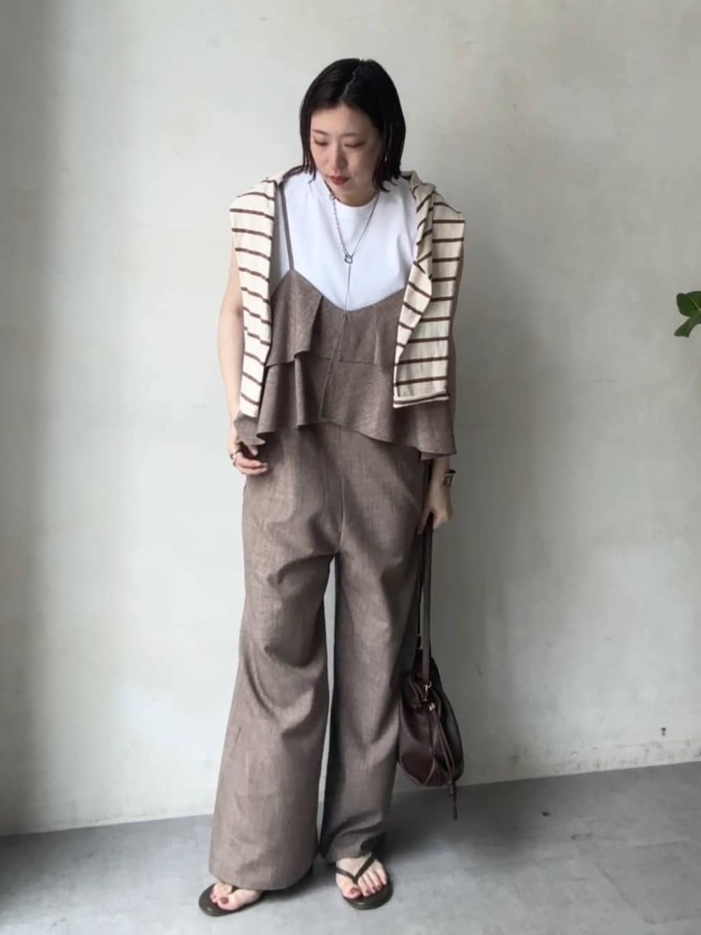 ベージュ系のつなぎ/オールインワン、ホワイト系のTシャツ/カットソーを着用したレディースの春コーディネートの4枚目の写真