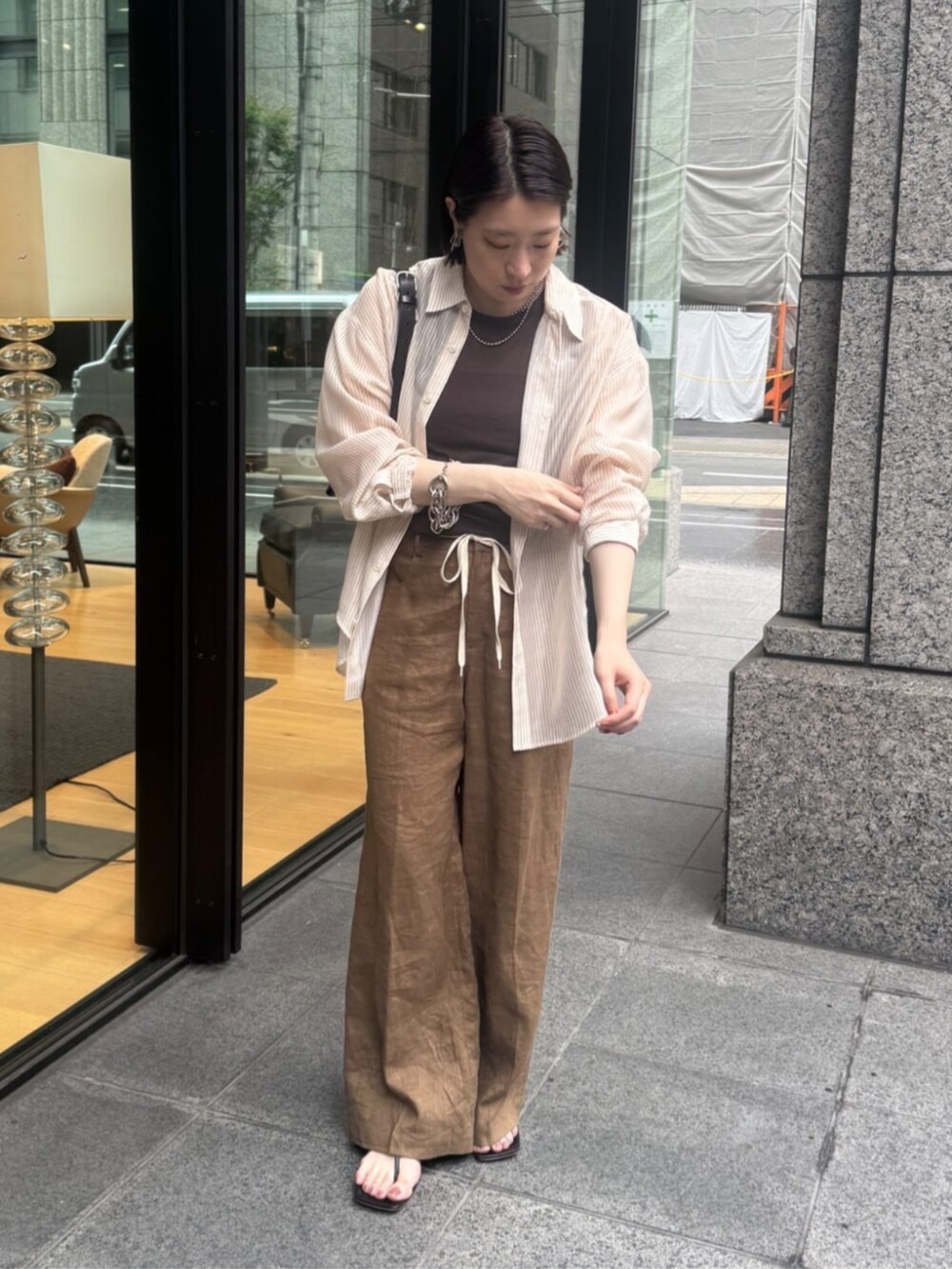 ブラウン系のショルダーバッグ、ブラウン系のTシャツ/カットソー、ベージュ系のシャツ/ブラウスを着用したレディースの夏コーディネートの9枚目の写真