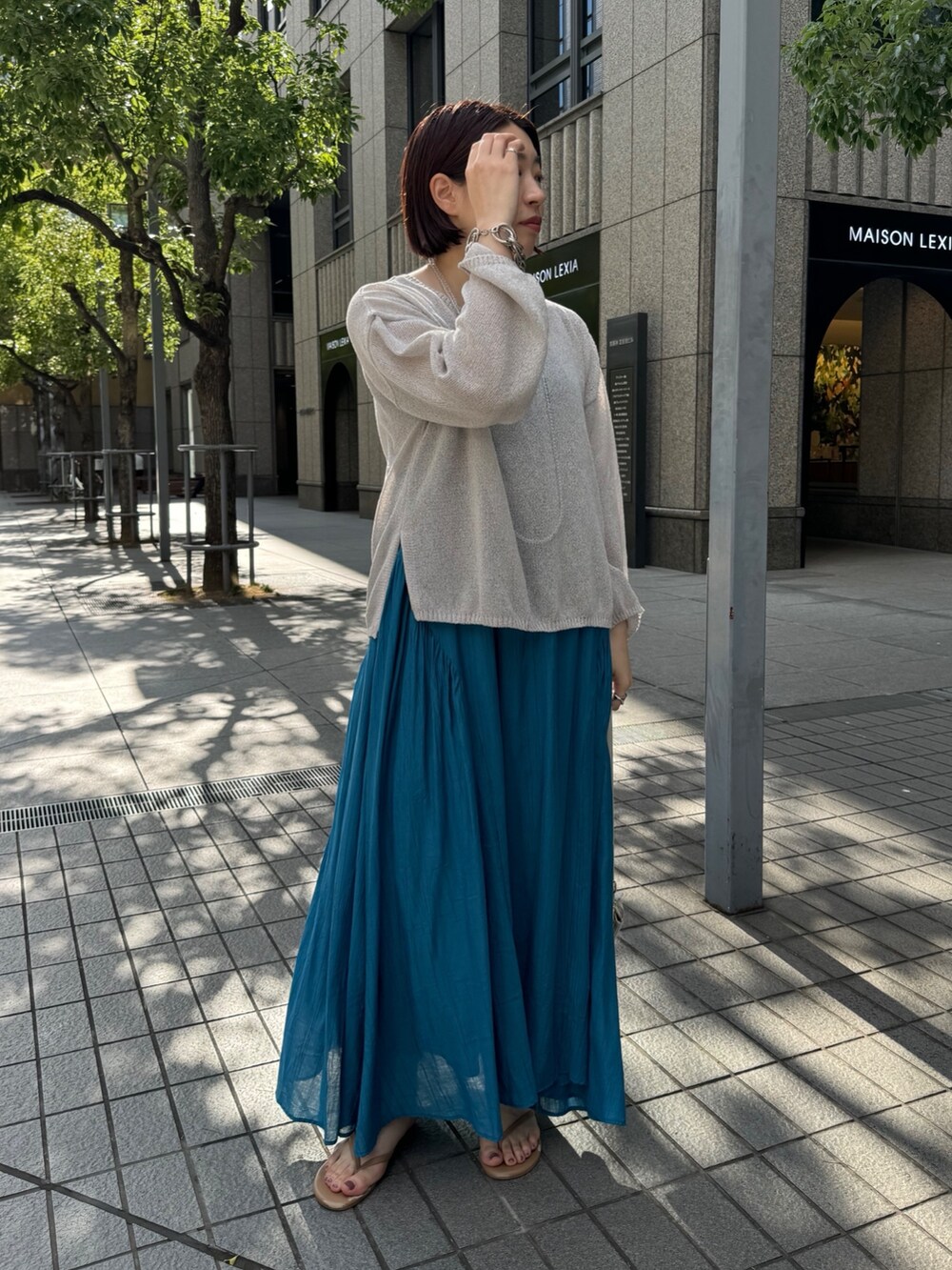 ブルー系のワンピース、ベージュ系のニット/セーター、ホワイト系のショルダーバッグを着用したレディースの夏コーディネートの4枚目の写真