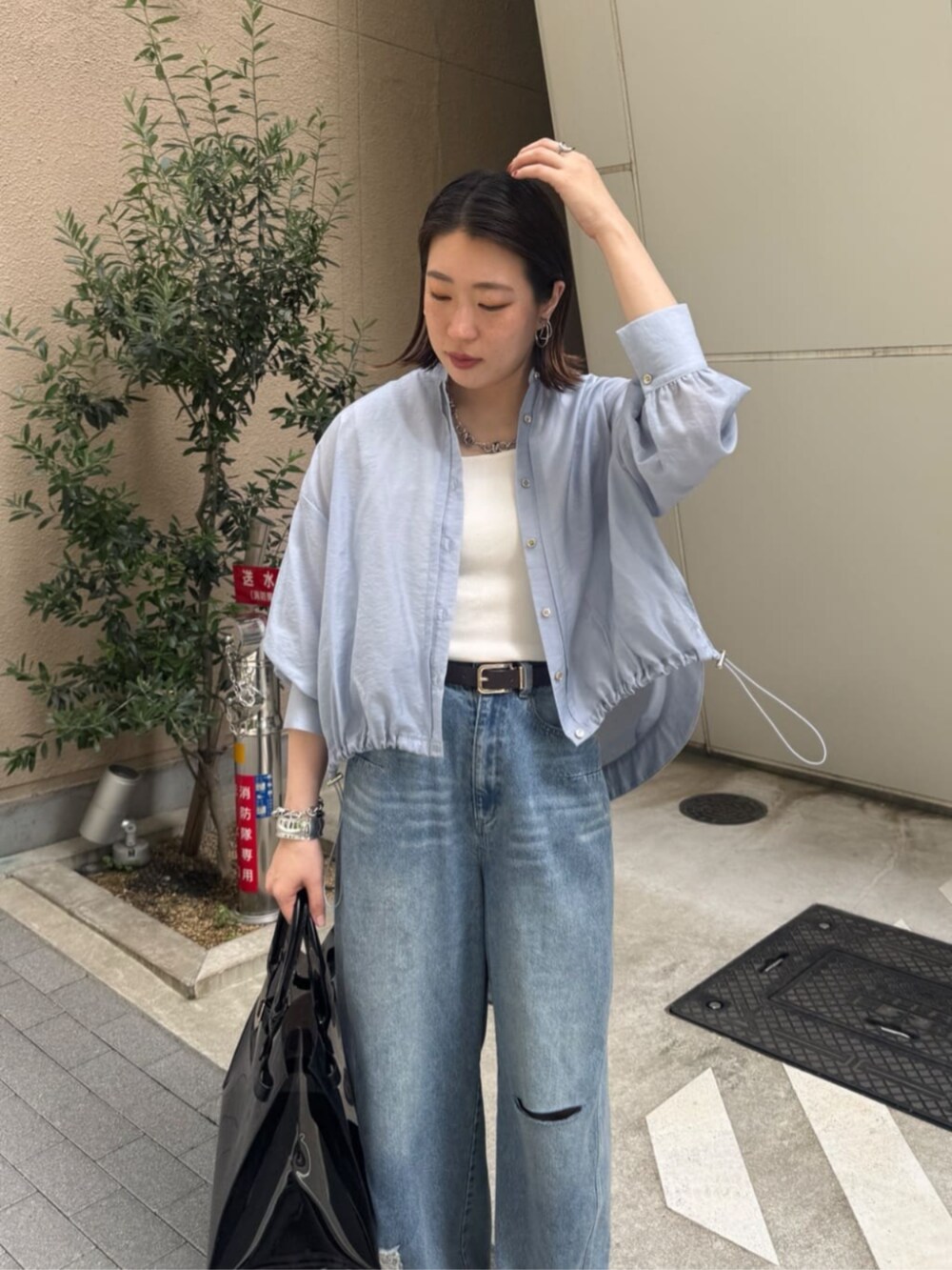 ホワイト系のタンクトップ、ブラック系のショルダーバッグ、ブルー系のデニムパンツを着用したレディースの春コーディネートの8枚目の写真