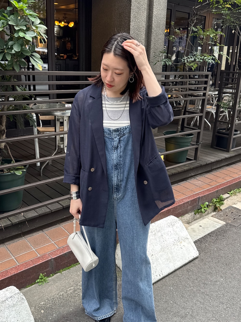 ブルー系のつなぎ/オールインワン、ブルー系のテーラードジャケット、グレー系のニット/セーターを着用したレディースの春コーディネートの3枚目の写真