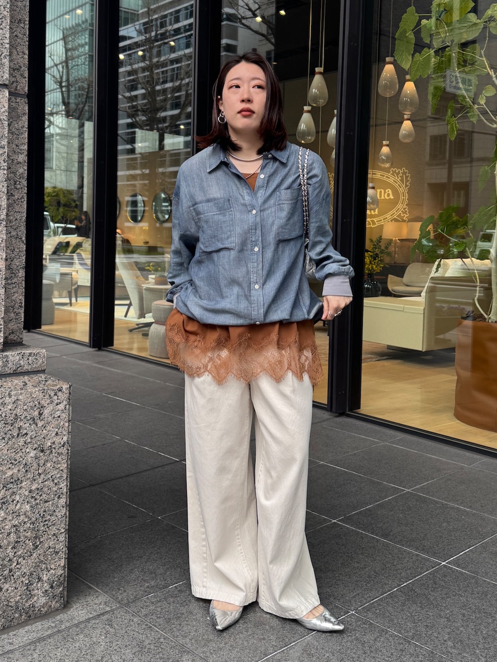 ブルー系のシャツ/ブラウス、ブラウン系のTシャツ/カットソー、ベージュ系のデニムパンツを着用したレディースの春コーディネートの2枚目の写真