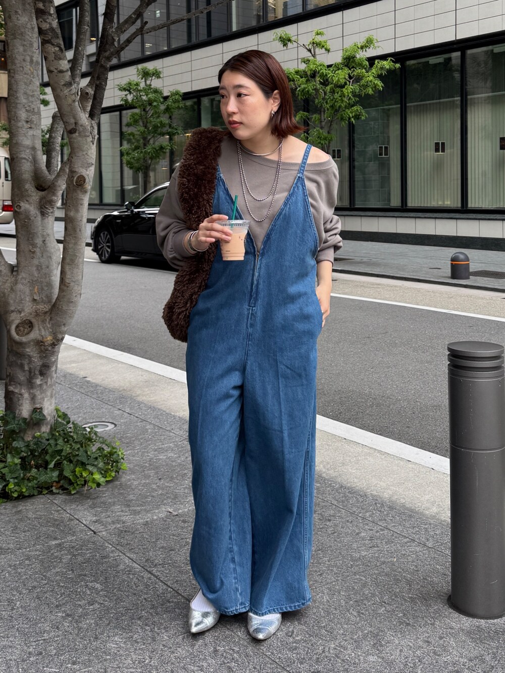 ブルー系のつなぎ/オールインワン、ベージュ系のスウェット、ブラウン系のショルダーバッグを着用したレディースの秋コーディネートの6枚目の写真
