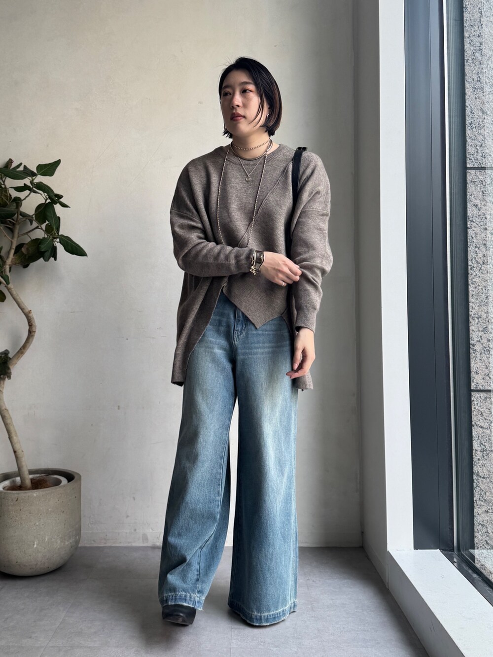 ブルー系のその他アウター、ブルー系のデニムパンツ、グリーン系のニット/セーターを着用したレディースの秋コーディネートの9枚目の写真