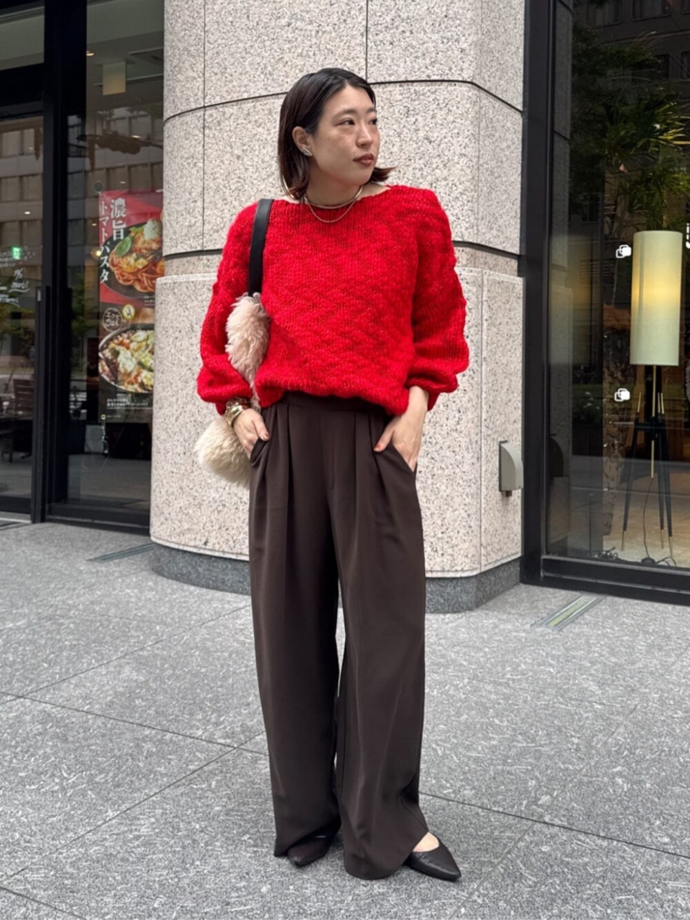 ブラウン系のスラックス、ホワイト系のショルダーバッグ、レッド系のニット/セーターを着用したレディースの秋コーディネートの2枚目の写真