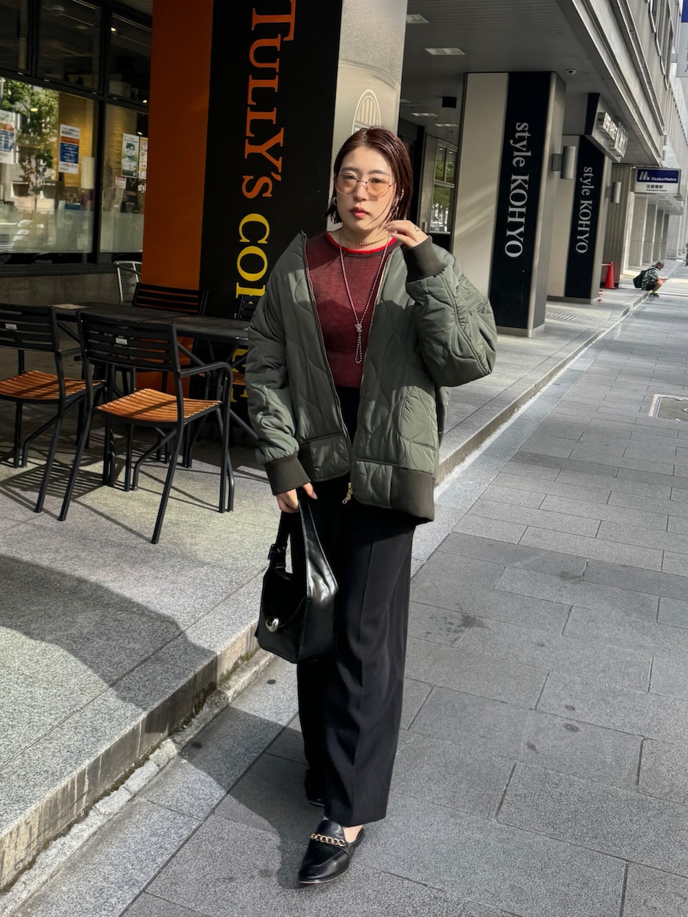 ブラック系のその他パンツ、グリーン系のその他アウター、レッド系のニット/セーターを着用したレディースの秋コーディネートの2枚目の写真