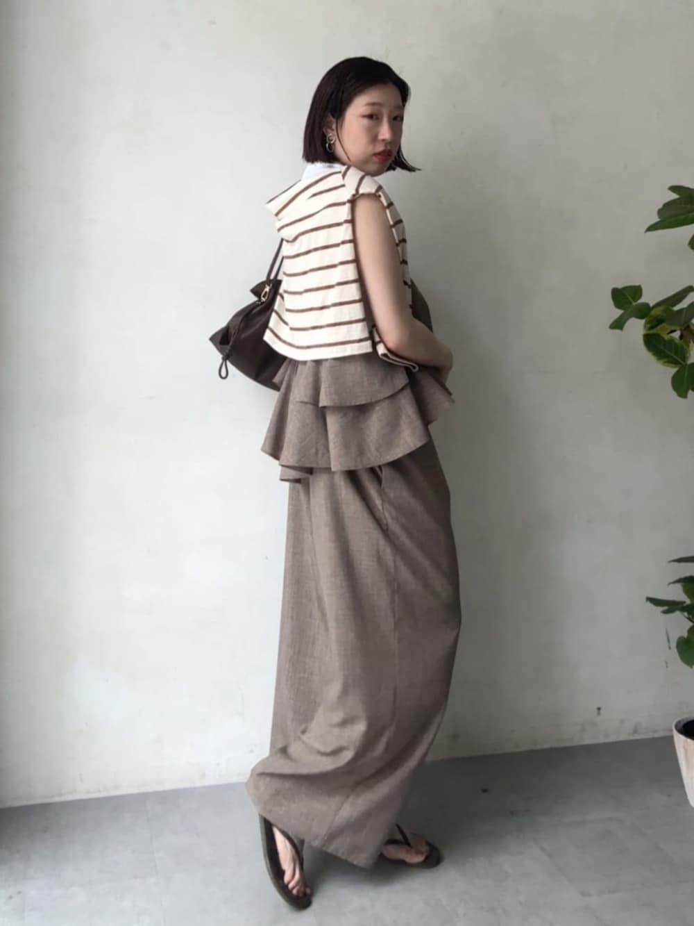 ベージュ系のつなぎ/オールインワン、ホワイト系のTシャツ/カットソーを着用したレディースの春コーディネートの2枚目の写真