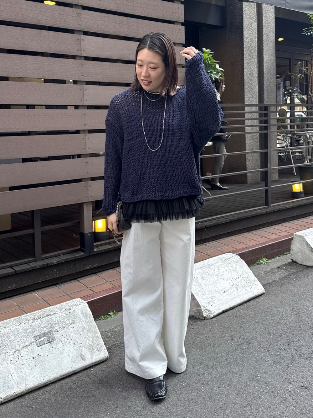 ブルー系のニット/セーター、ブラック系のシャツ/ブラウス、ホワイト系のその他パンツを着用したレディースの春コーディネートの4枚目の写真