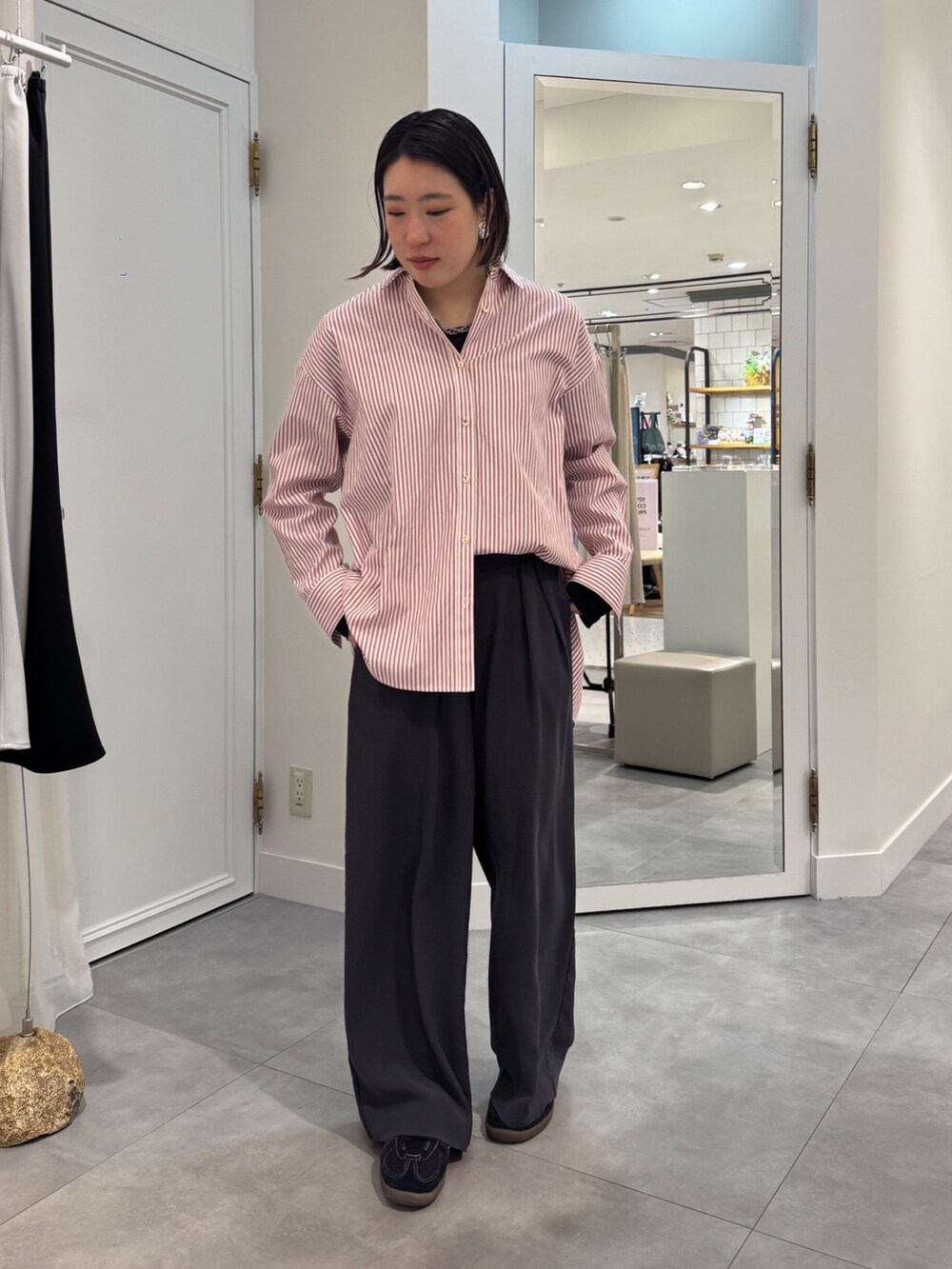 ブラウン系のスラックス、レッド系のシャツ/ブラウス、ブルー系のTシャツ/カットソーを着用したレディースの春コーディネートの2枚目の写真