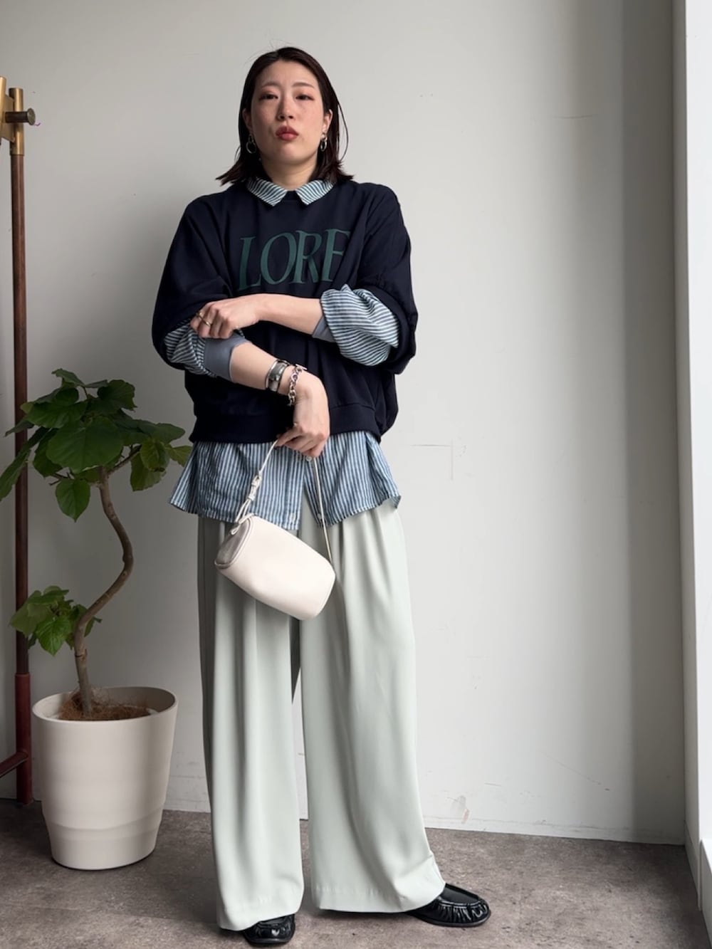 グリーン系のスラックス、ブルー系のシャツ/ブラウス、ブルー系のTシャツ/カットソーを着用したレディースの春コーディネートの4枚目の写真