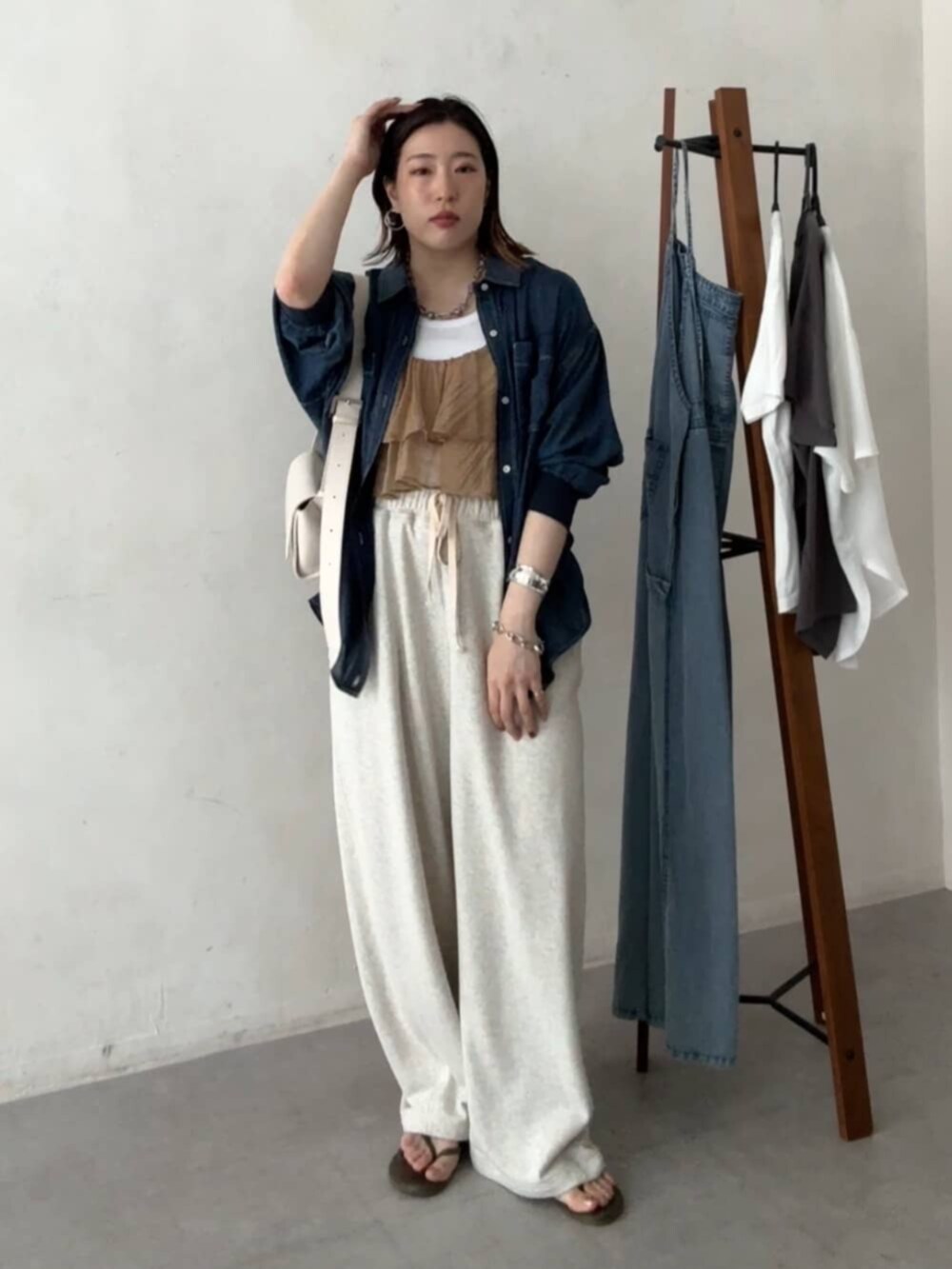 ホワイト系のショルダーバッグ、ベージュ系のその他パンツ、ブルー系のシャツ/ブラウスを着用したレディースの春コーディネートの2枚目の写真